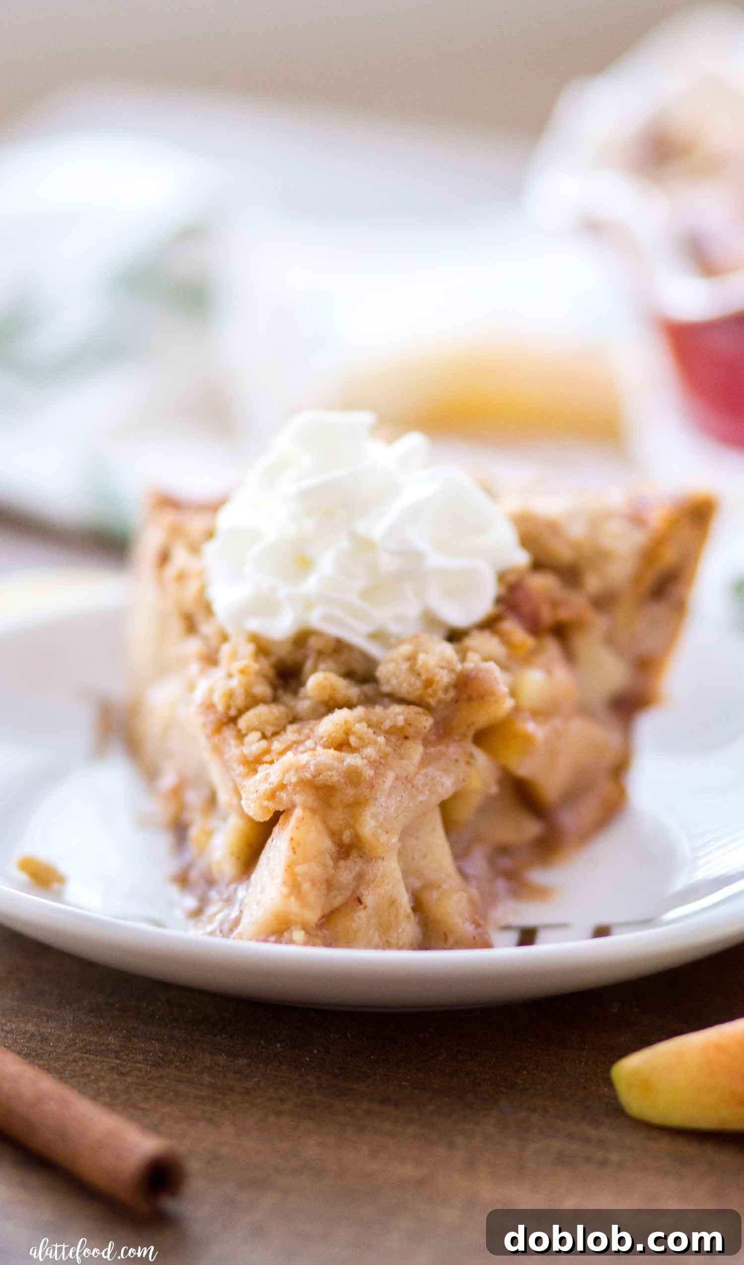 A slice of Cinnamon Roll Dutch Apple Pie revealing the apple filling and cinnamon roll crust.