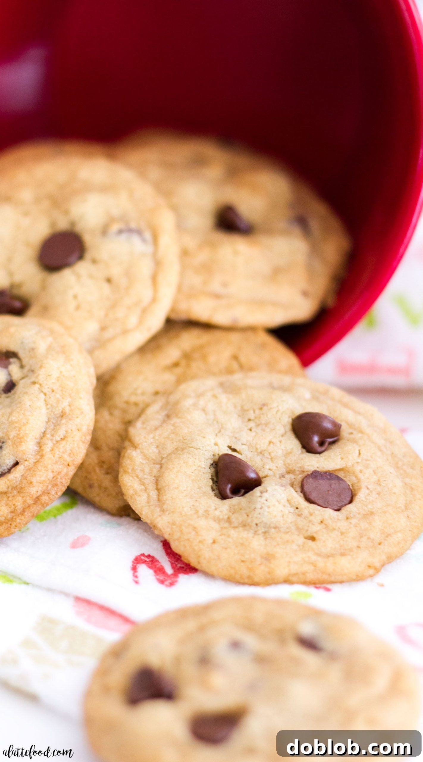 A close-up shot of a single mini chocolate chip cookie with a bite taken out, revealing its soft interior.