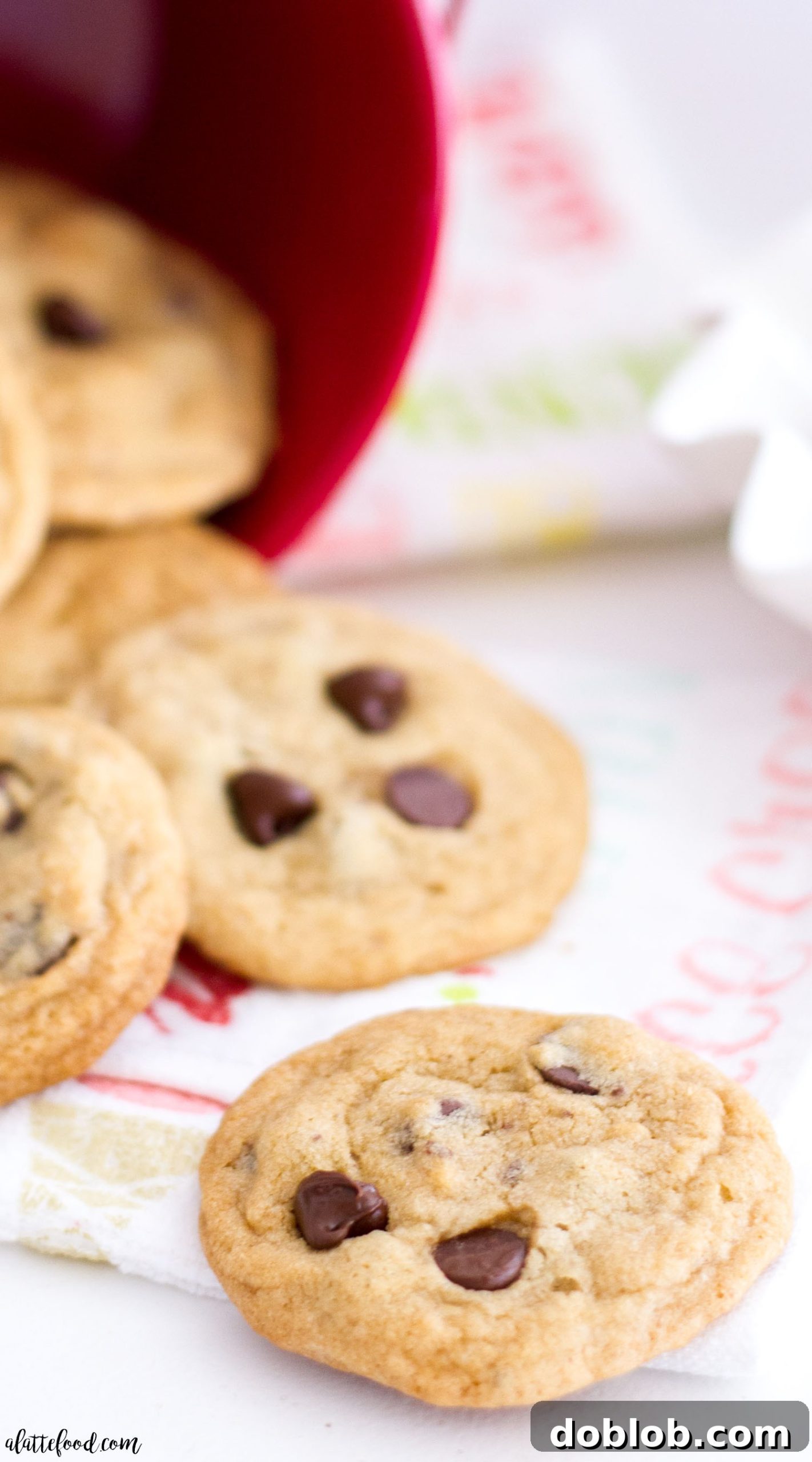 An overhead view of several mini chocolate chip cookies artfully arranged on a rustic wooden surface.