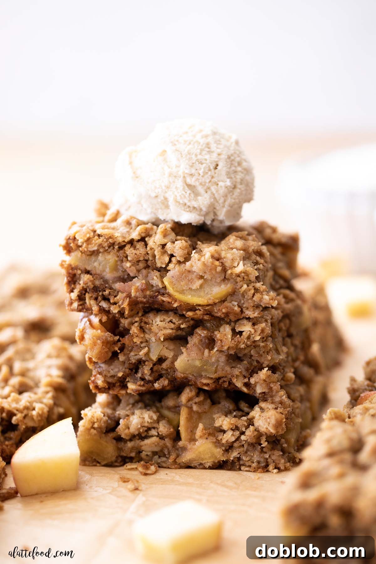 ice cream topped apple crumb bars on parchment paper.