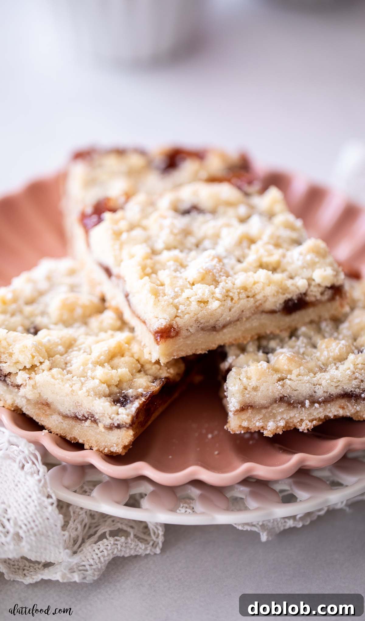 crumb topped strawberry jam shortbread bars on pink plate