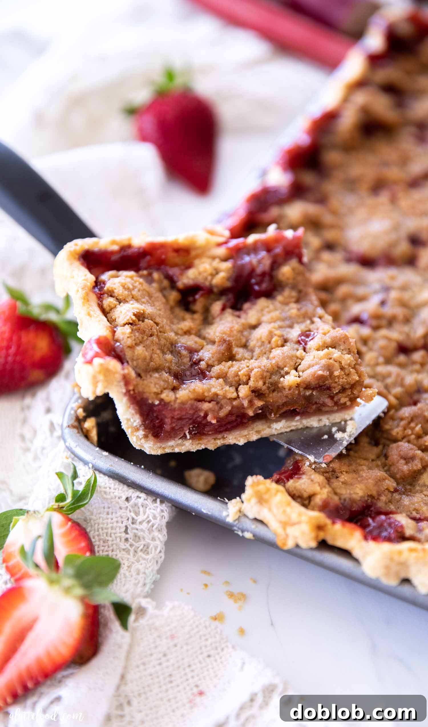 strawberry rhubarb crumb bar slice sitting on pie server
