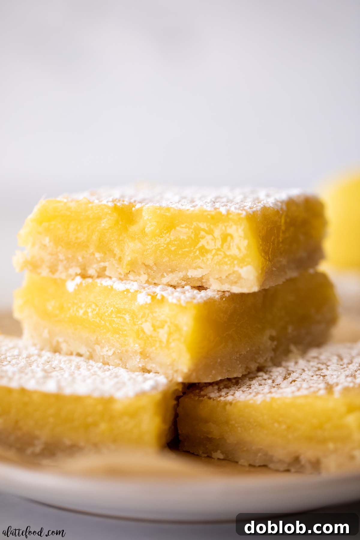 shortbread crusted lemon bars stacked on white plate