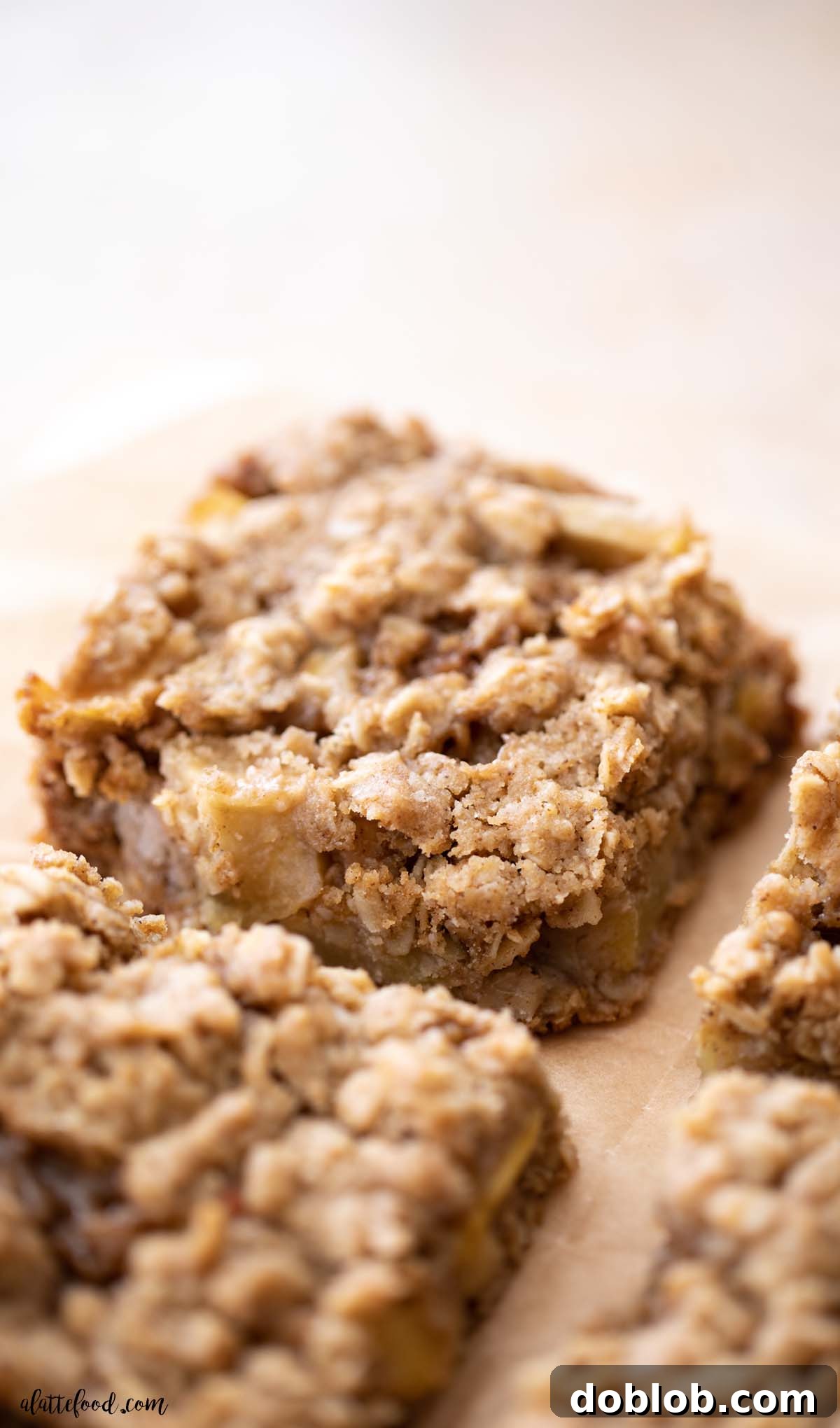 baked apple pie crumb bars sliced on brown parchment paper.