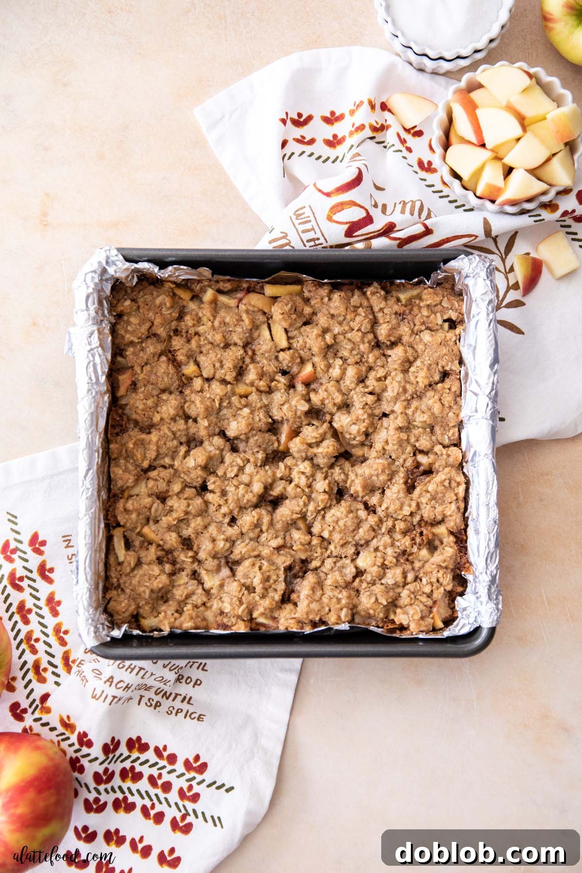 baked apple pie crumb bars in a foil-lined baking dish.