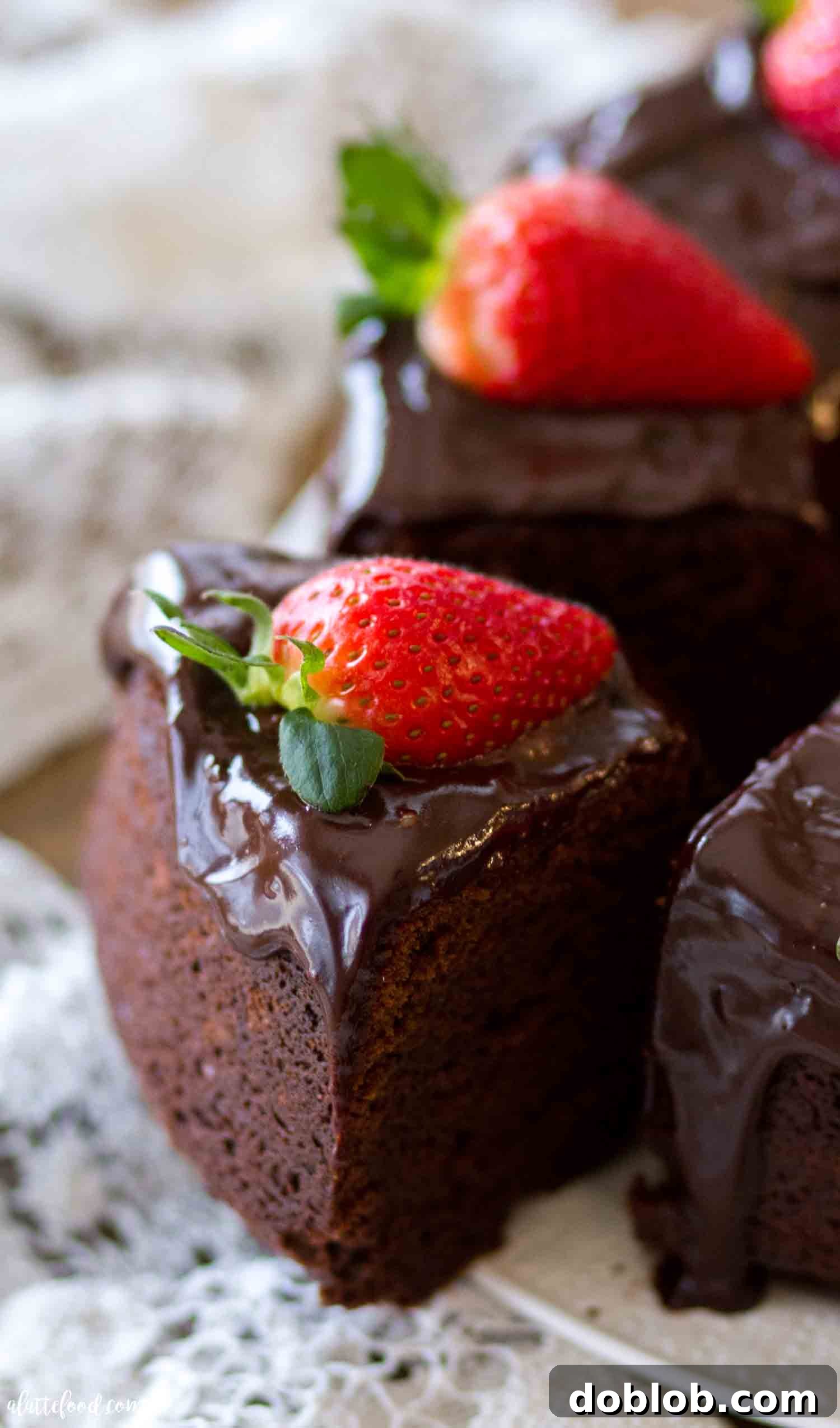 A rich and fudgy sour cream chocolate pound cake, topped with ganache. Made with melted chocolate, it's one of the best chocolate cake recipes and an all-time favorite bundt cake! A close-up view of a ganache-topped chocolate pound cake slice, revealing its fudgy interior and moist texture.