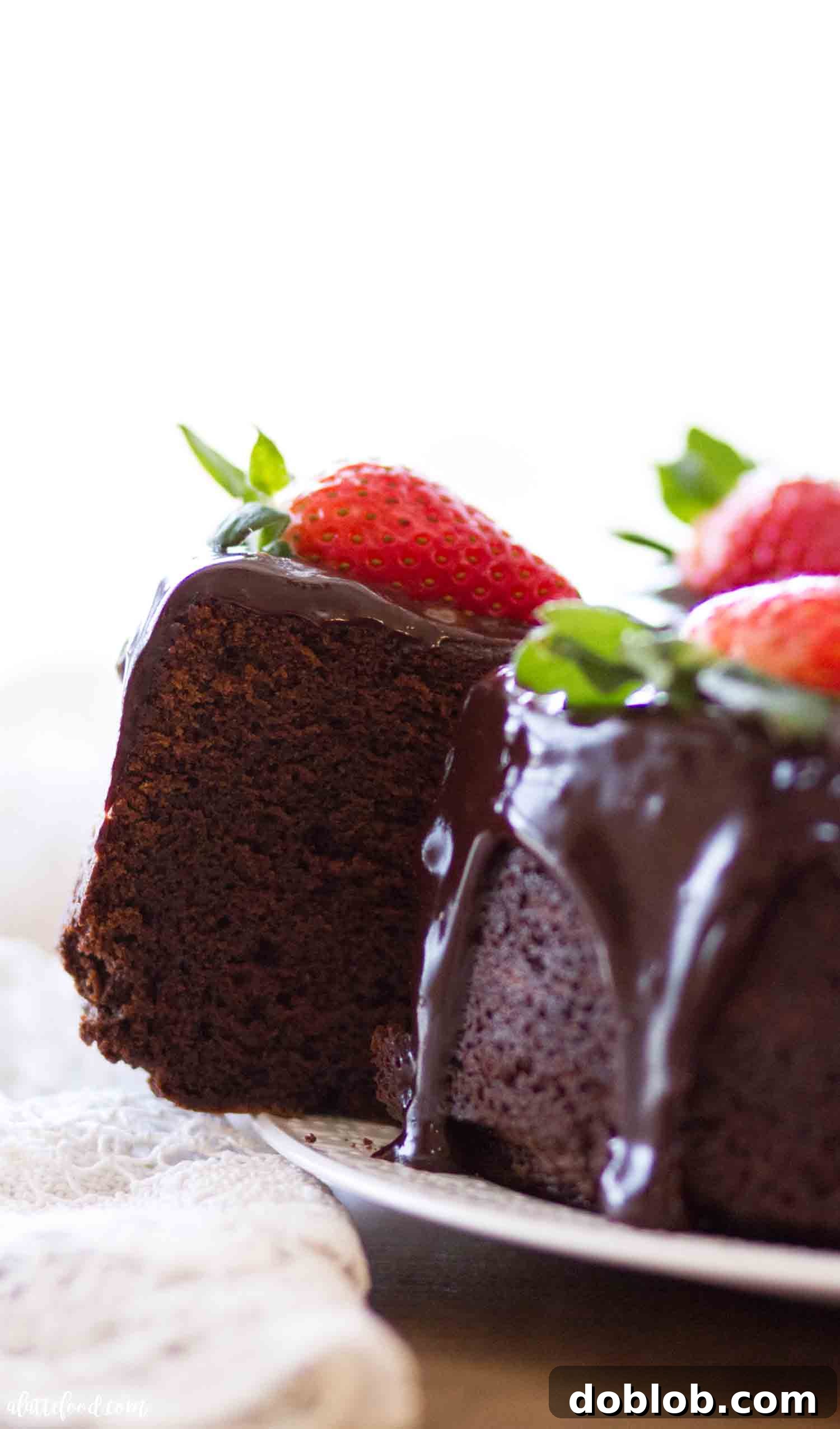 This sour cream chocolate pound cake recipe, made with melted chocolate, is my favorite moist chocolate pound cake, perfect for Valentine’s Day and all chocolate dessert lovers! A beautifully presented chocolate pound cake with ganache, sliced and served on a platter with fresh strawberries, ready to be enjoyed.