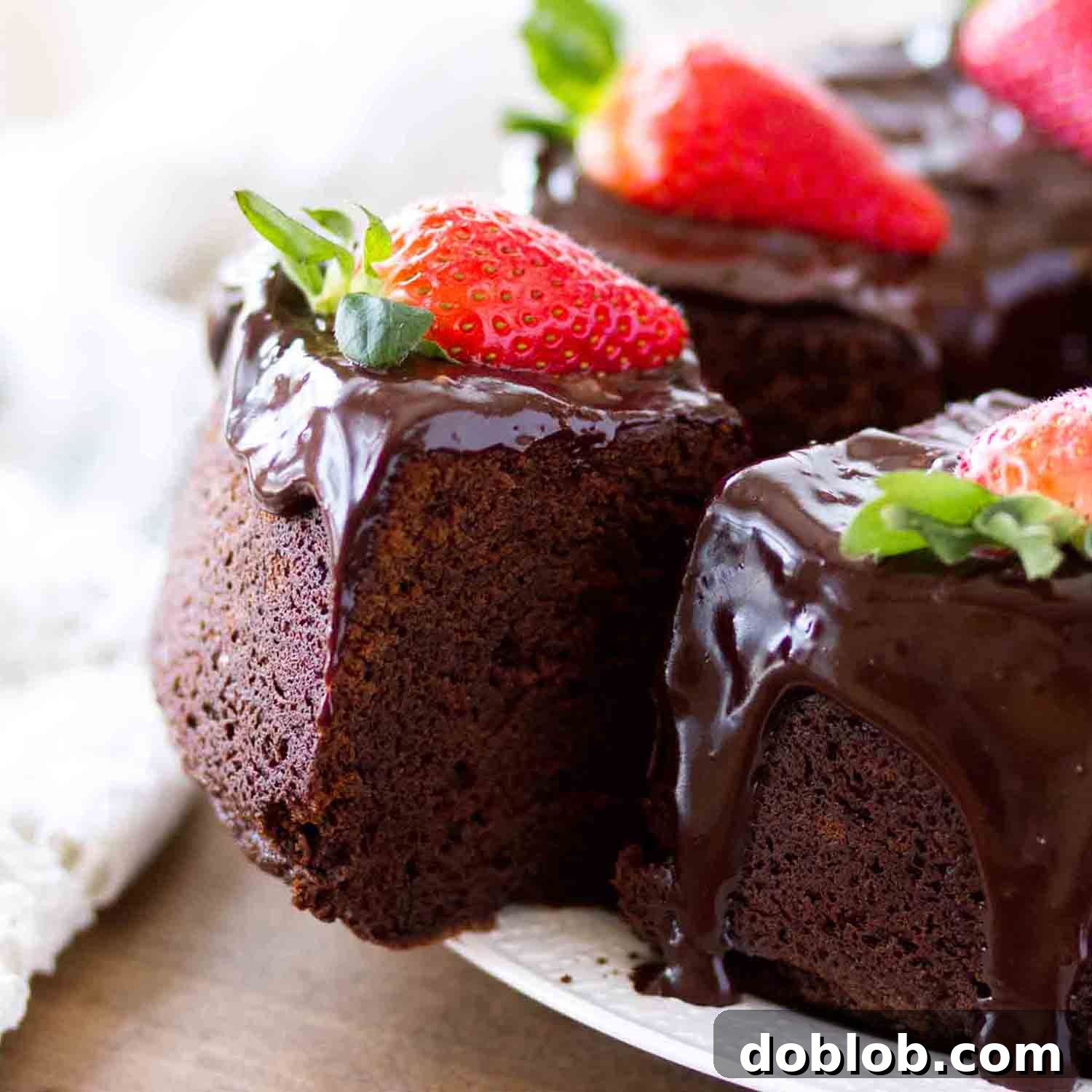 A slice of rich chocolate pound cake with ganache and fresh strawberries, a delightful dessert.