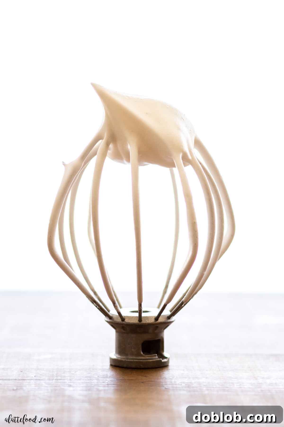 standing mixer whisk with egg whites at stiff peaks.