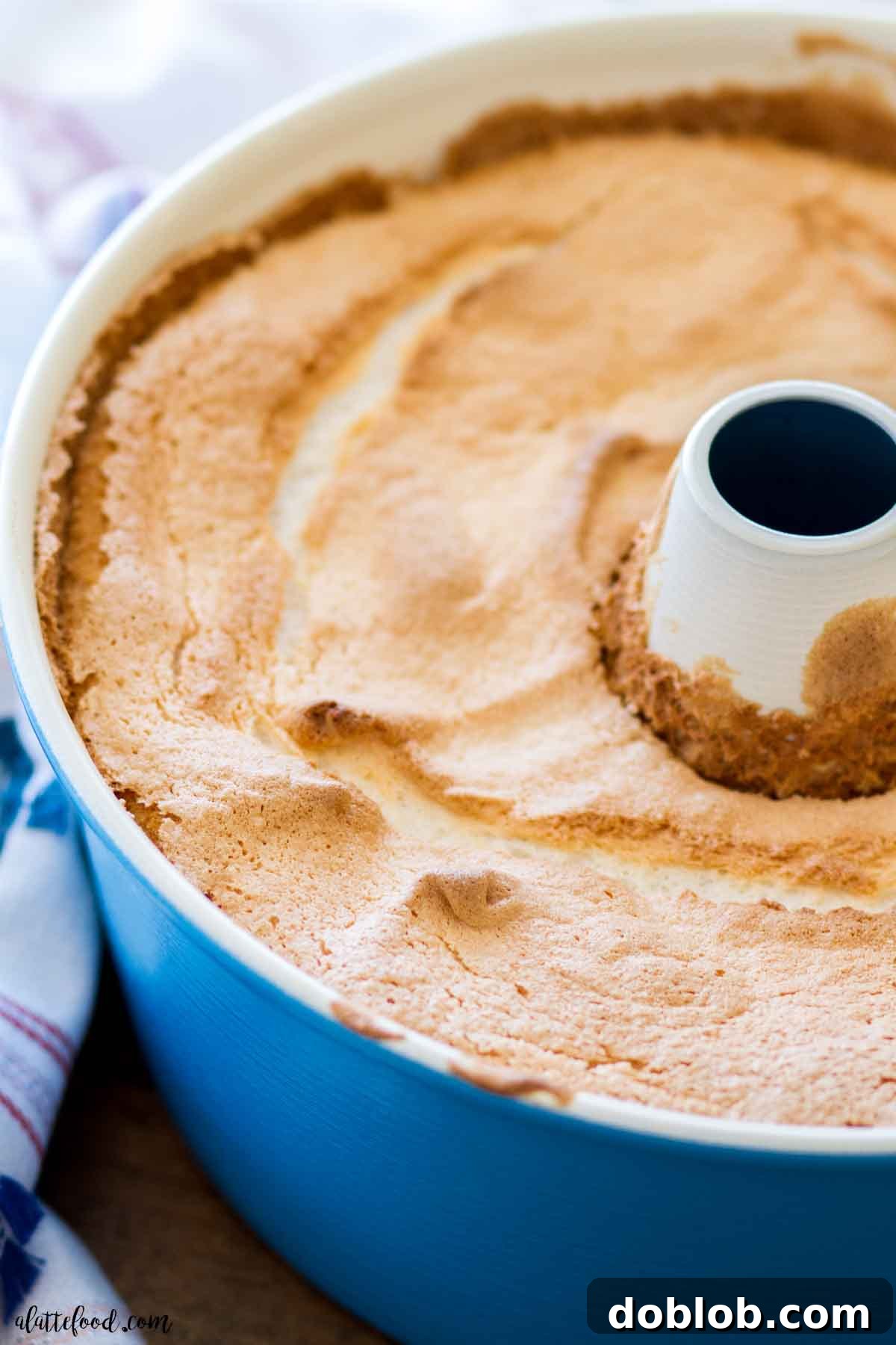 baked angel food cake in a blue tube pan after it has cooled.