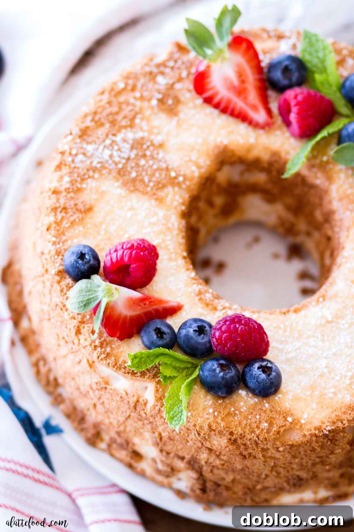 soft and fluffy angel food cake with fresh berries decorating the top of the cake.