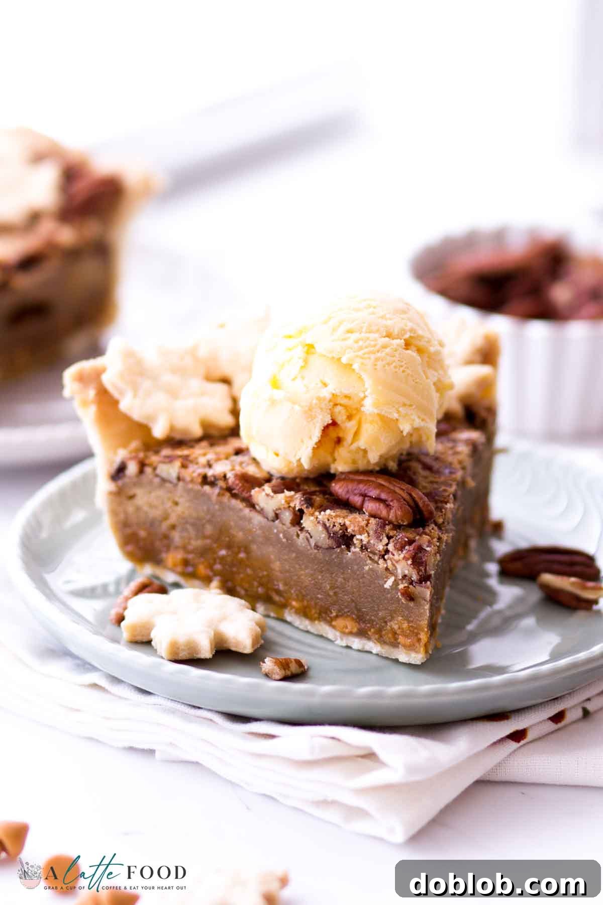 A generous slice of Butterscotch Pecan Pie, exquisitely topped with a melting scoop of ice cream, presented on a plate.