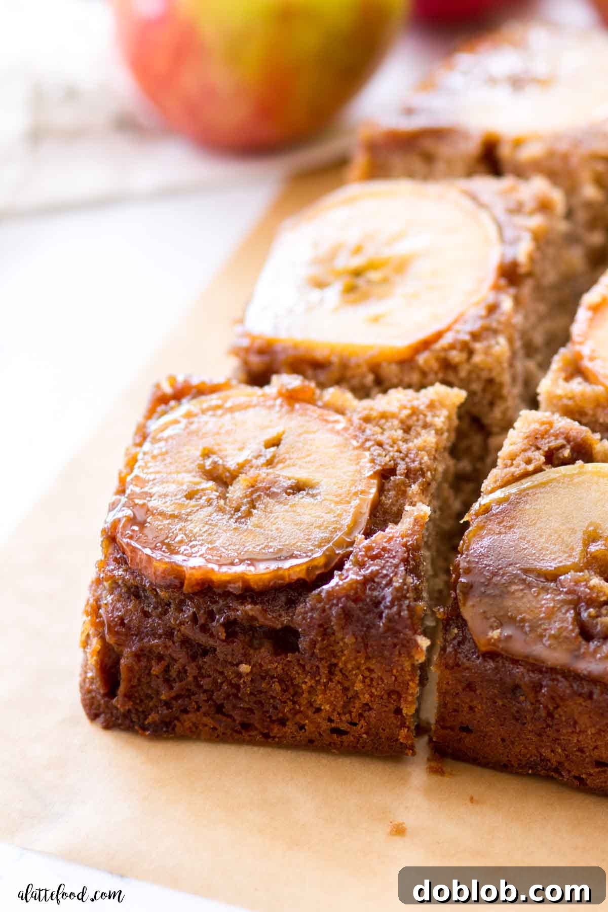 Caramel Apple Upside Down Cake cut into squares on brown parchment paper.