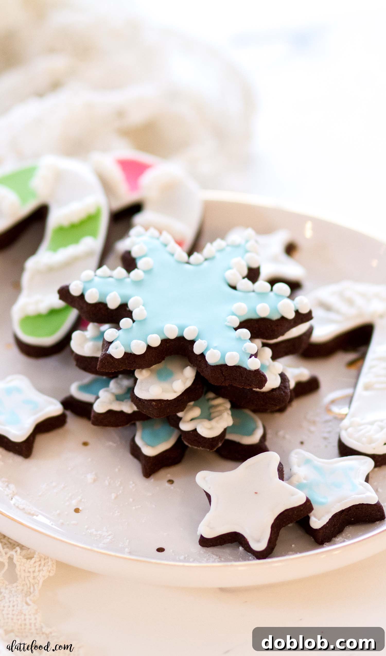 Learn how to make royal icing to decorate your sugar cookies! This is an easy royal icing recipe, and it's perfect for beginners. With a helpful video and plenty of tips, you can't go wrong with this royal icing recipe! Vibrant blue royal icing elegantly decorating chocolate sugar cookies, perfect for any celebration.
