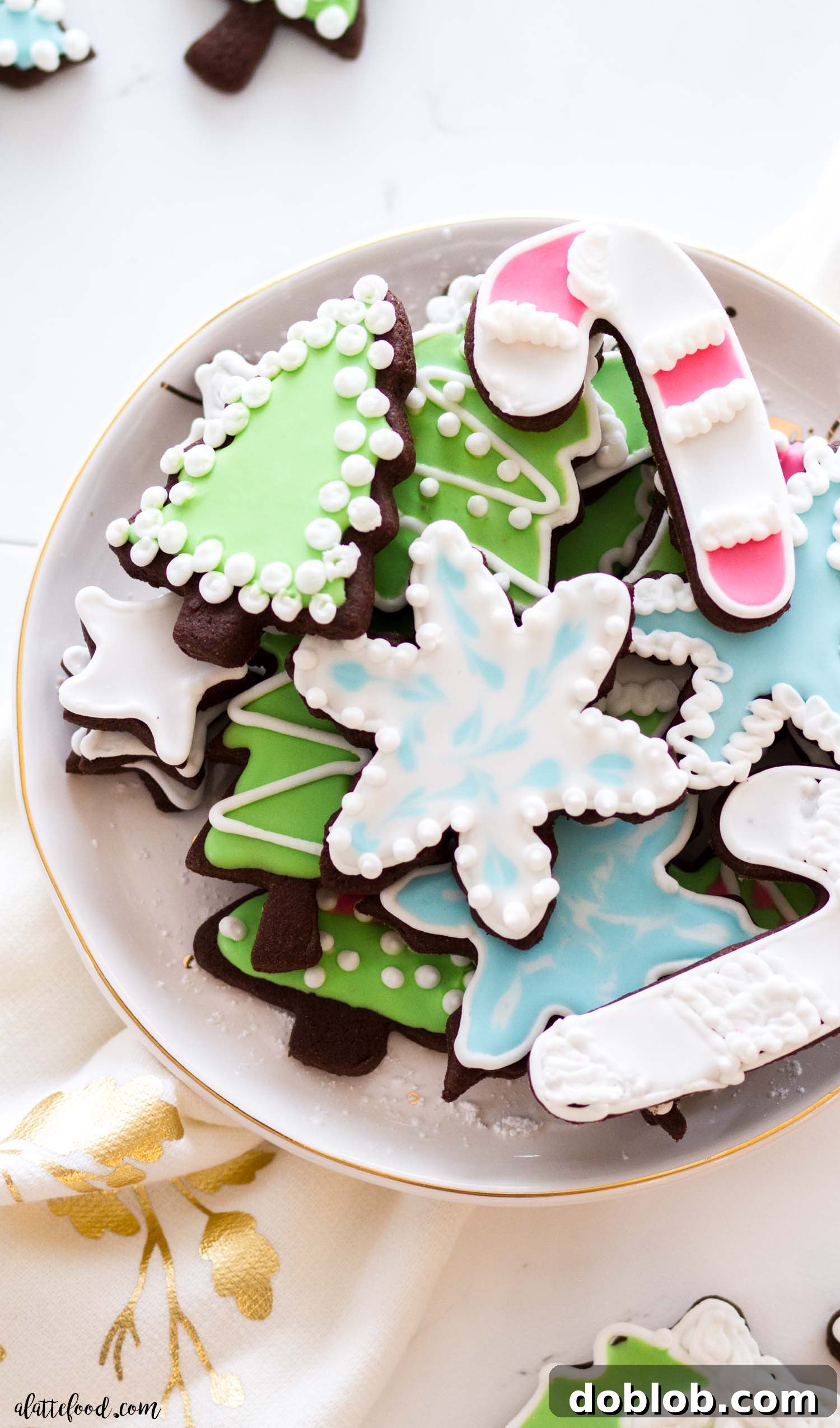 Learn how to make the best royal icing! This easy recipe has all the tips and tricks for beginners, plus a video showing some easy steps on flooding, piping and wet on wet techniques. A beautiful array of sugar cookies expertly decorated with easy royal icing, showcasing various beginner-friendly techniques.