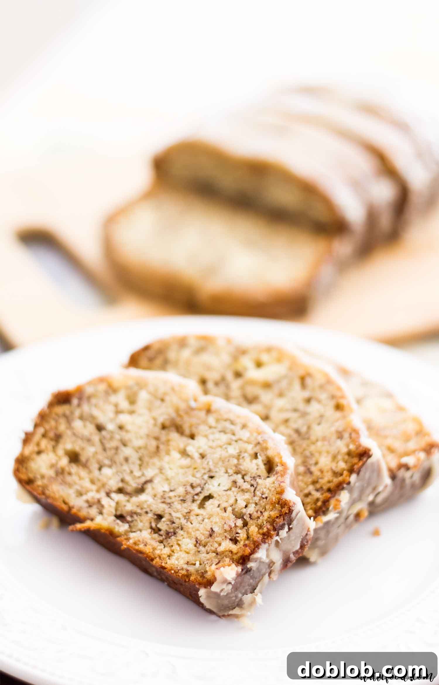 My favorite Banana Bread Recipe has a maple glaze that is to die for! It’s my mom’s banana bread recipe and it is so moist! One of our family favorite fall recipe! three slices of banana bread on a white plate