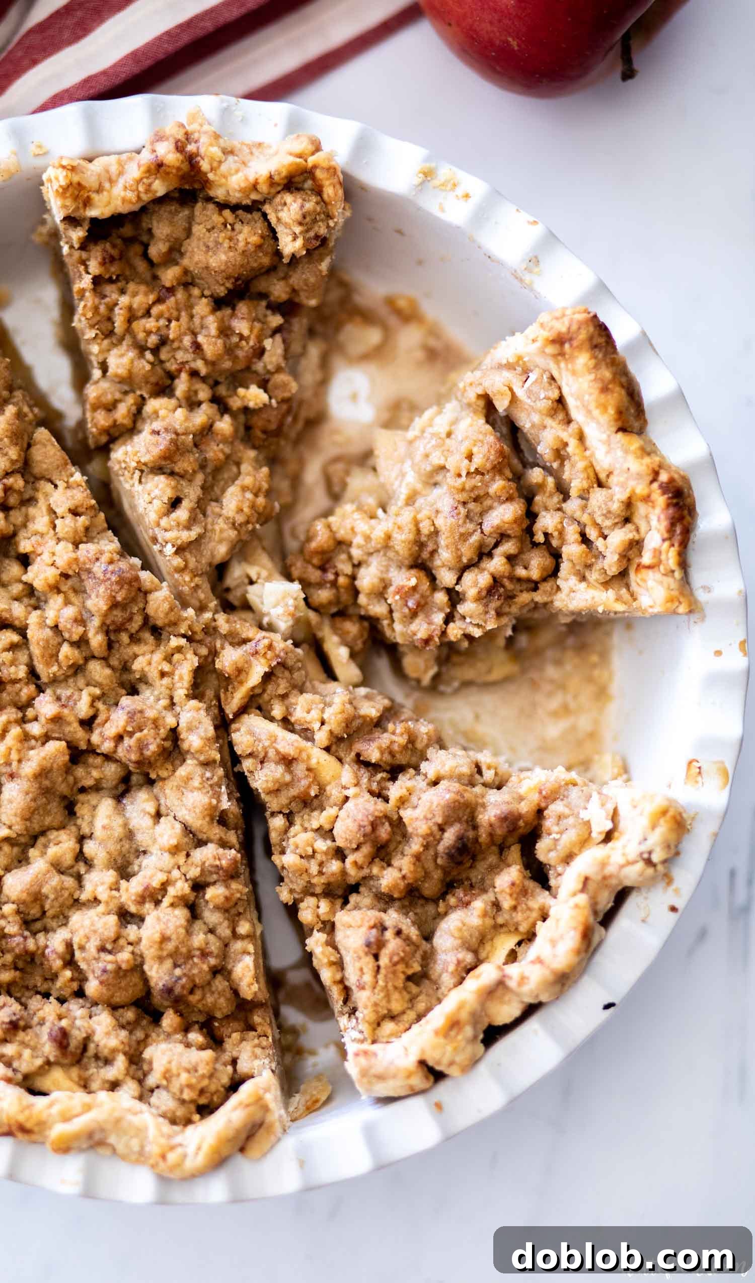 cut apple crumb pie in a white pie dish