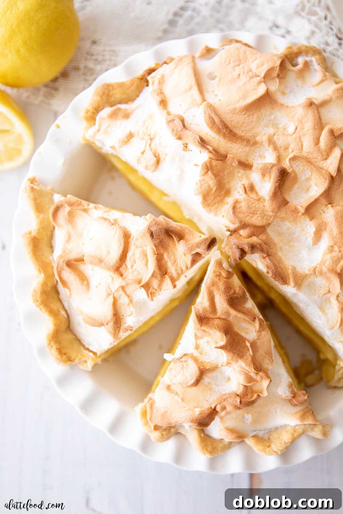 Lemon meringue pie still in the pie dish, with a slice removed, revealing the layers.