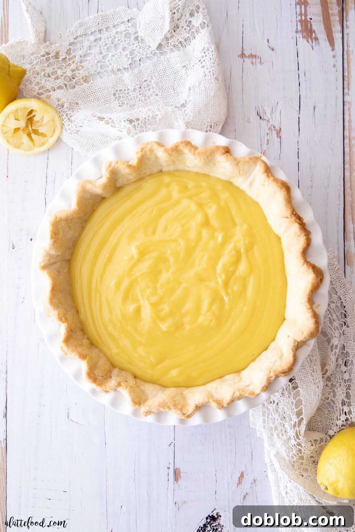 The vibrant lemon meringue pie filling, prior to being topped with meringue, sitting in a white pie dish.
