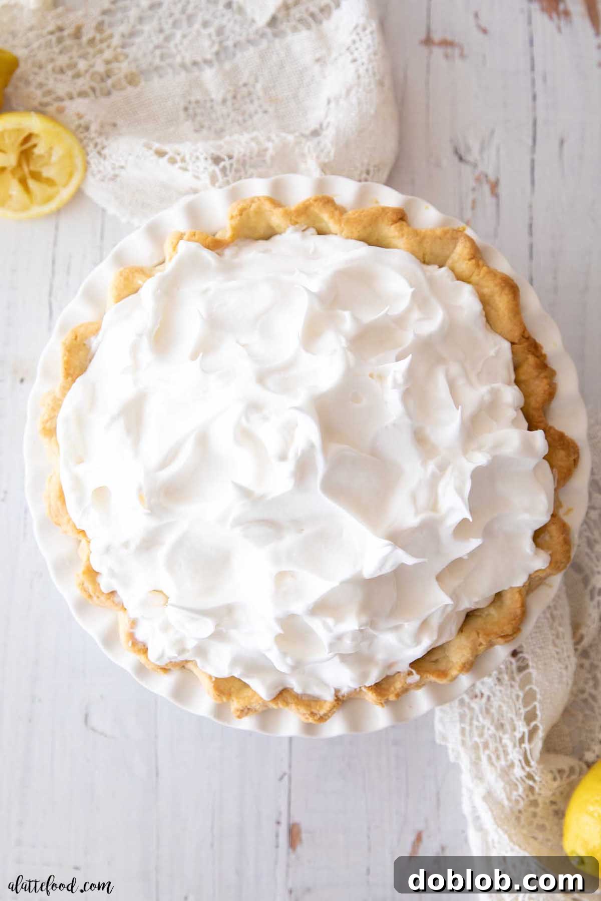 Unbaked lemon meringue pie with a smooth lemon filling in a white pie dish, ready for meringue.
