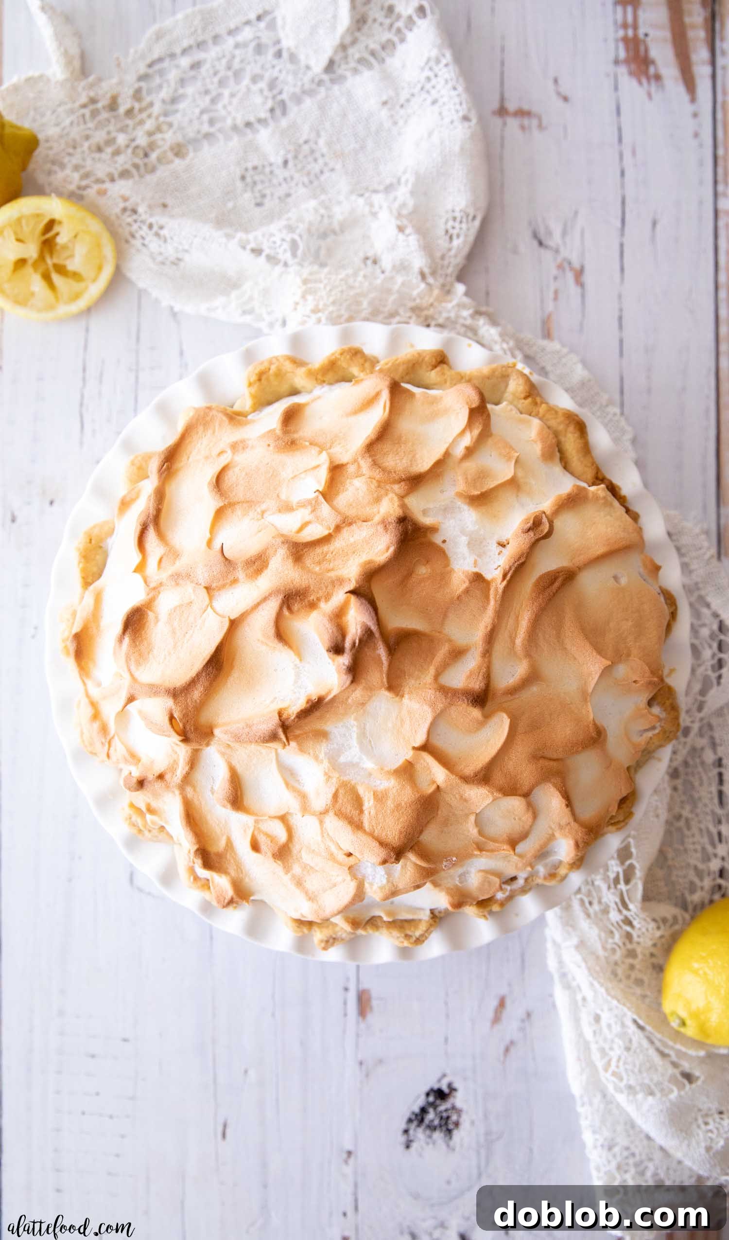 A freshly baked lemon meringue pie with golden, toasted meringue peaks.