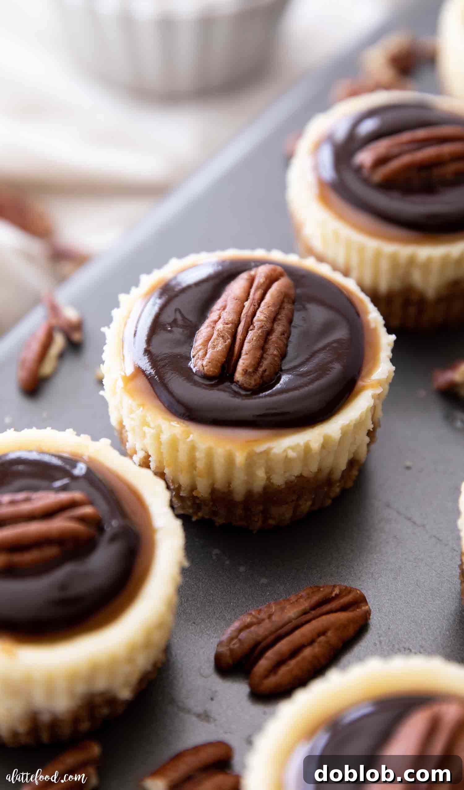 Sweet Honey Pistachio Delights with Cream Cheese 5 Four mini turtle cheesecakes on a baking sheet with caramel and pecans