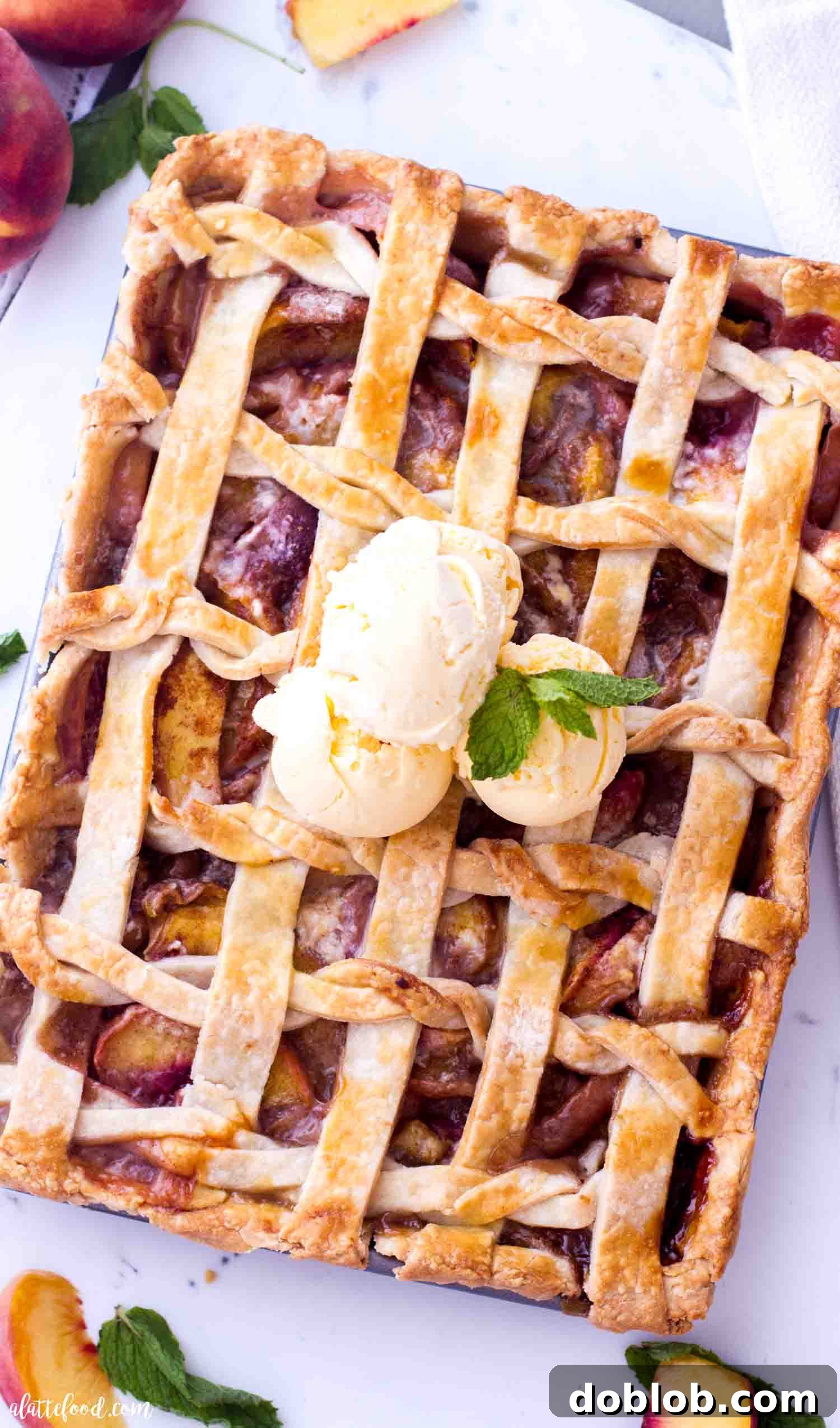 Fresh Peach Slab Pie topped with ice cream and a lattice crust.