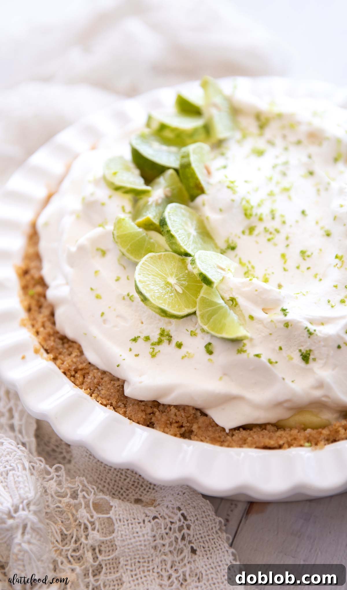 homemade key lime pie with a graham cracker crust in a white pie plate