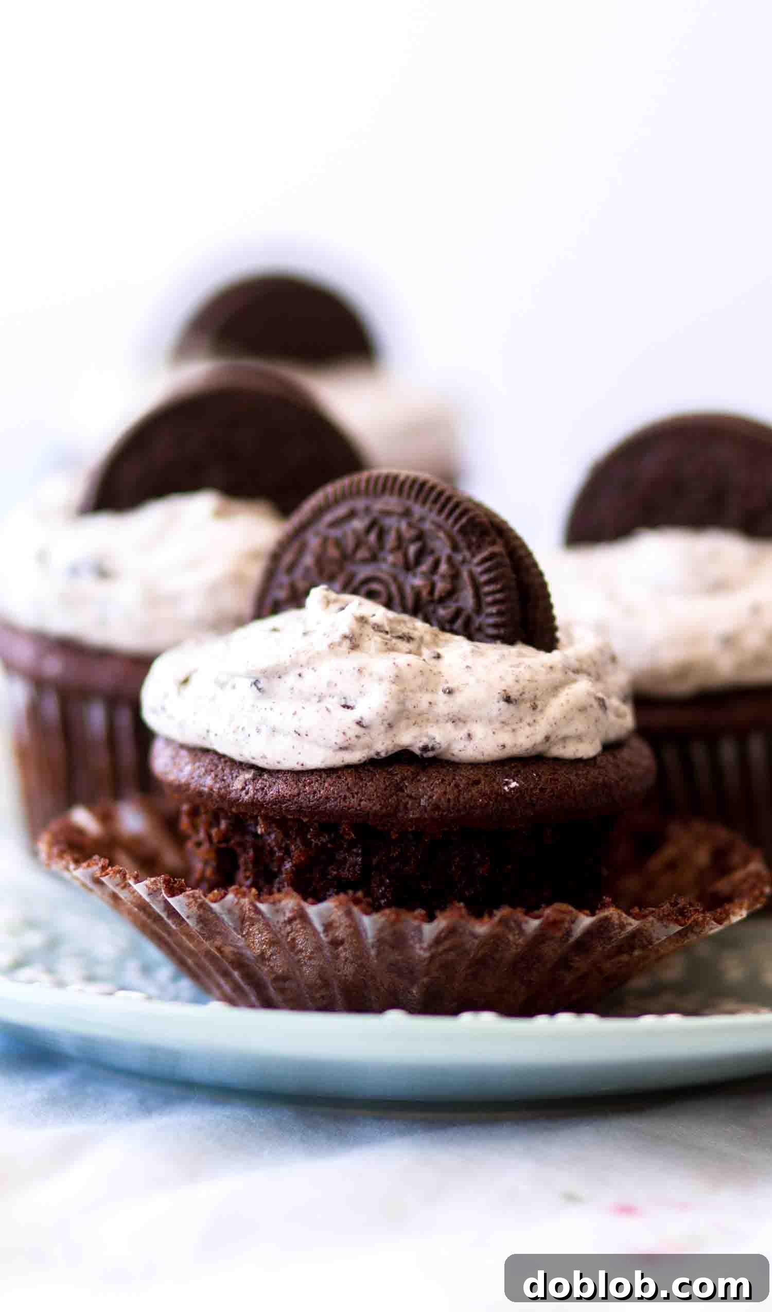 Moist chocolate Oreo cupcakes topped with cookies and cream frosting, a decadent treat for chocolate lovers.