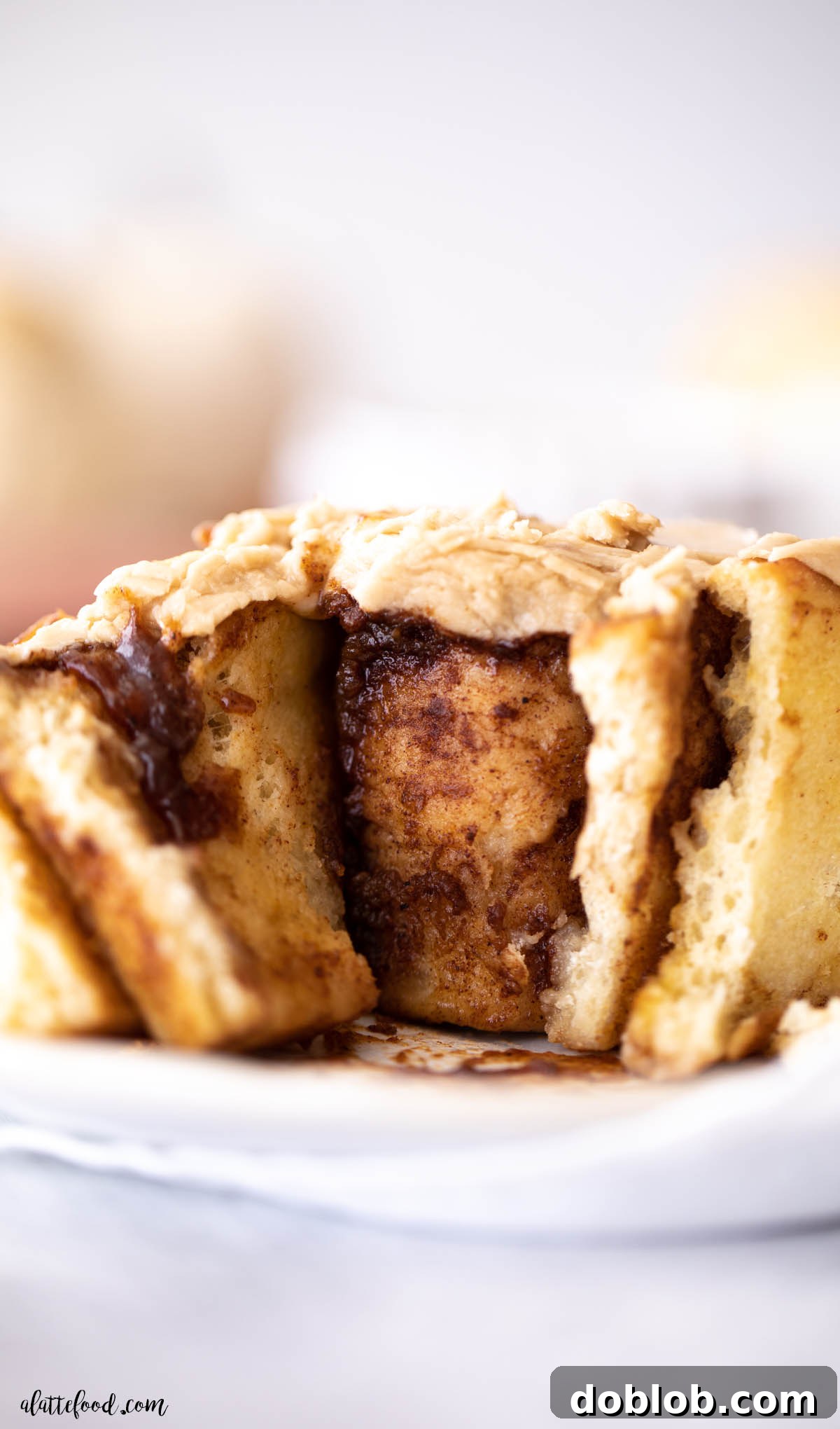 pumpkin butter cinnamon roll with brown sugar frosting cut in half