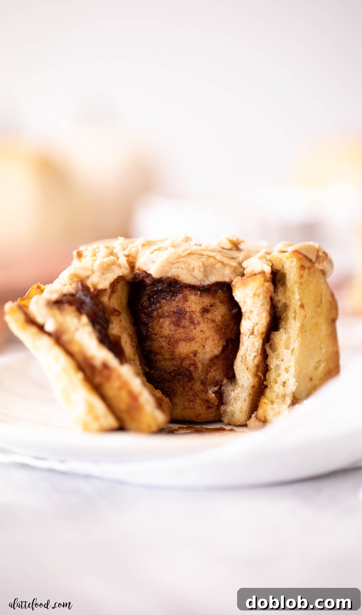 inside of pumpkin butter cinnamon roll with brown sugar frosting on white plate