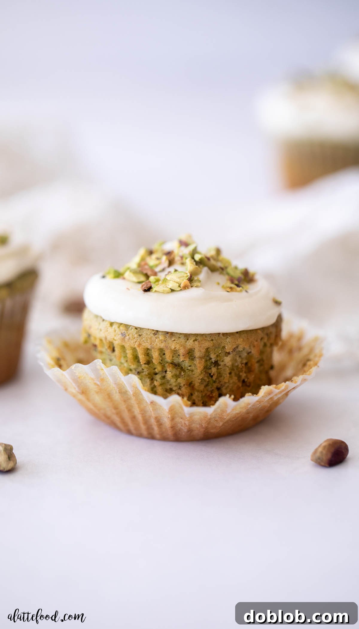 unwrapped pistachio cupcake with honey cream cheese frosting