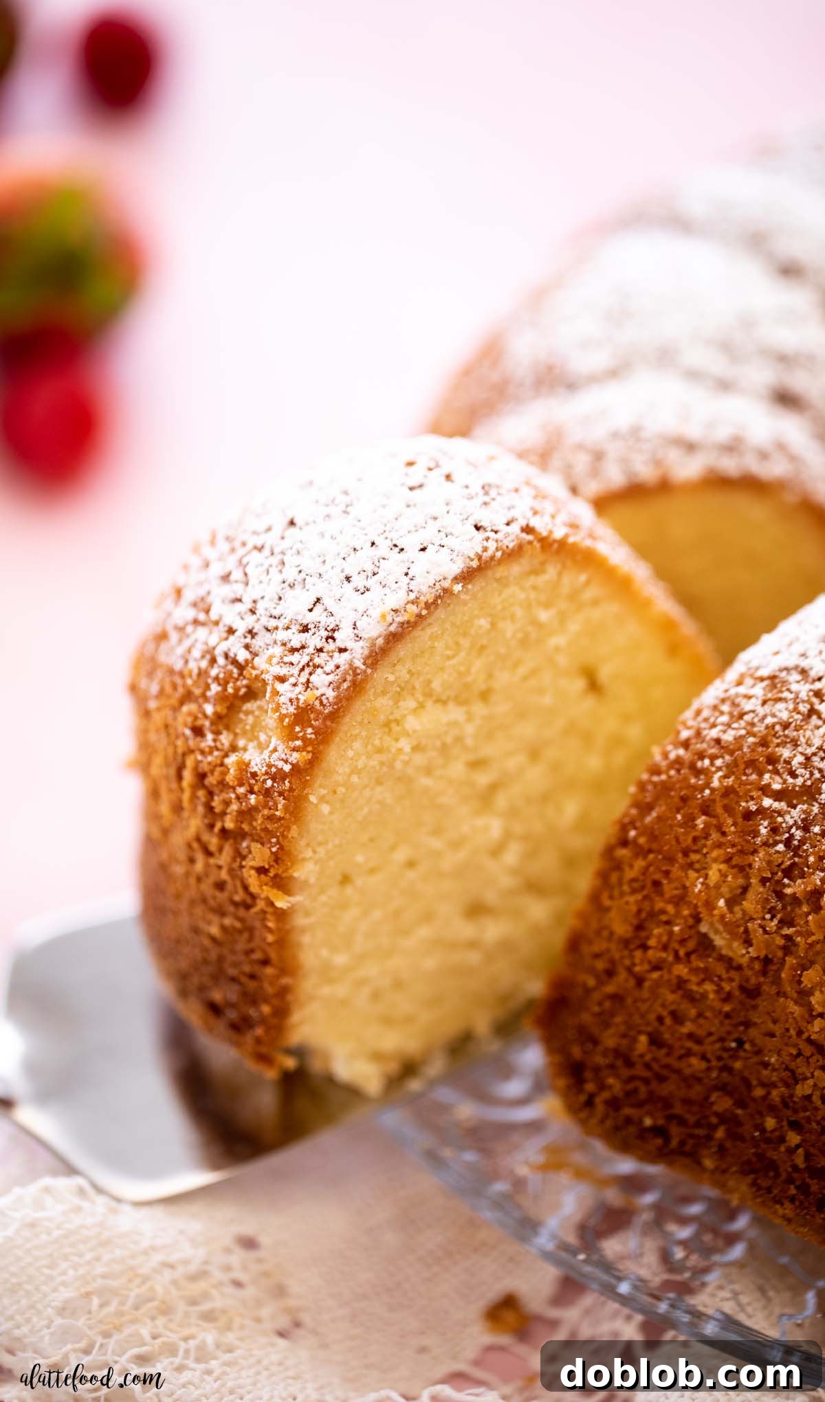 A generous slice of old-fashioned cream cheese pound cake, featuring a rich, buttery flavor and a soft yet dense texture, served on a silver cake server.