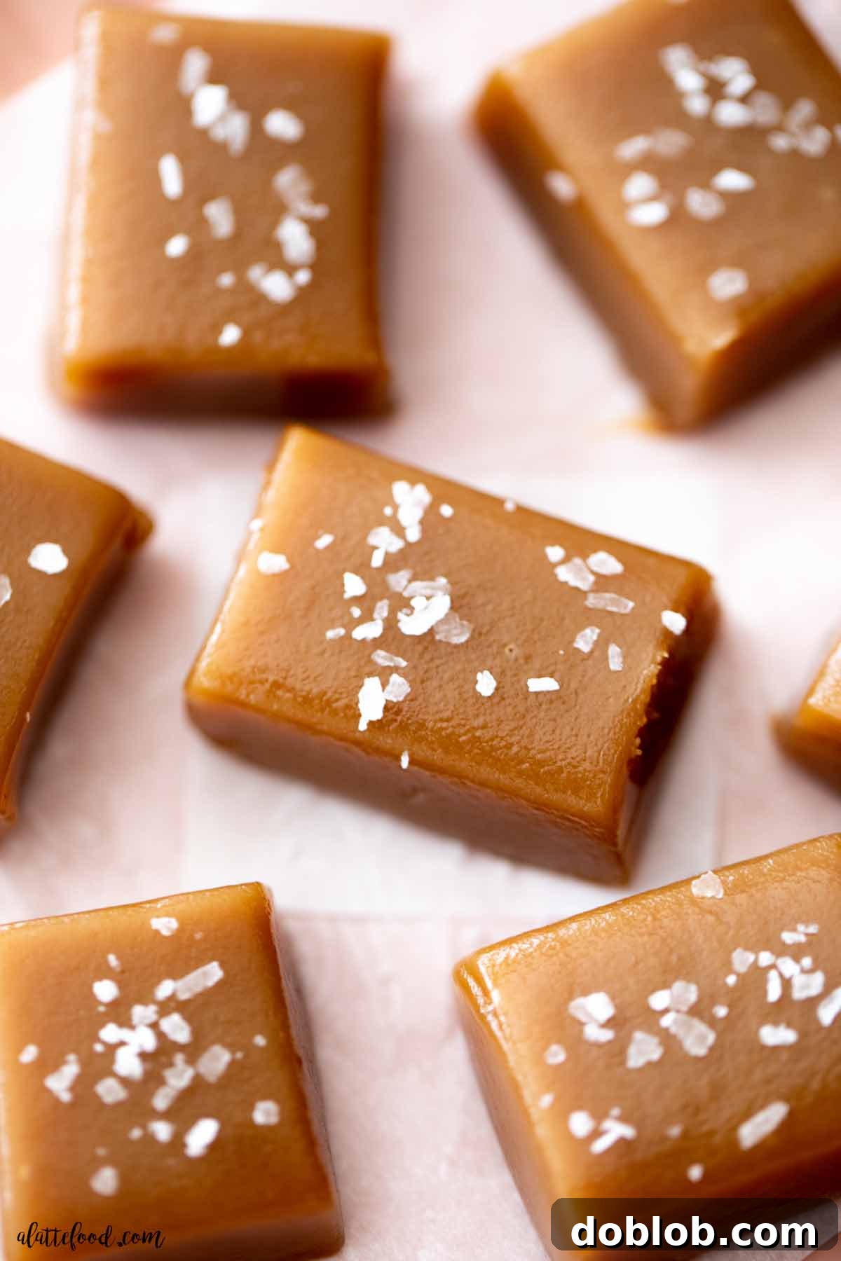 Microwave caramels cut into squares with flaked sea salt on top.