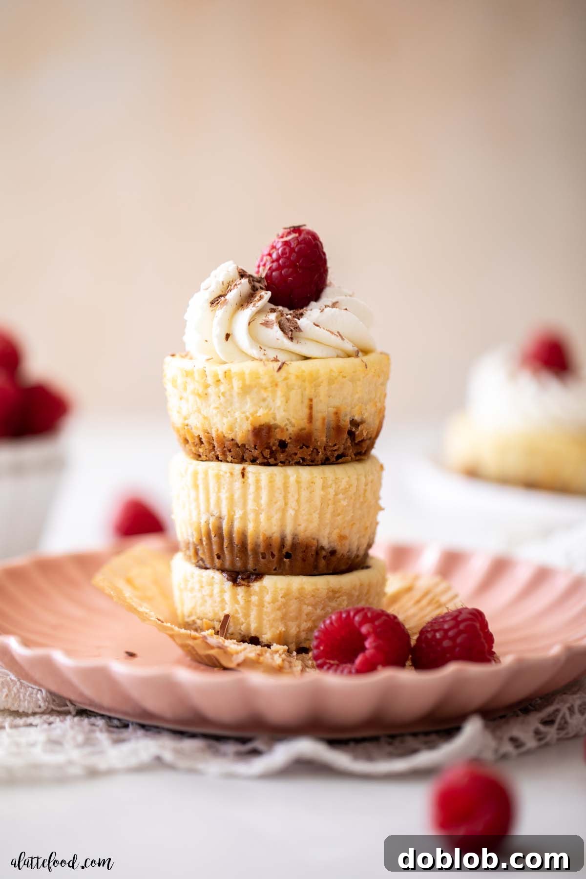 Three mini nutella cheesecakes stacked on top of each other on a pink plate.
