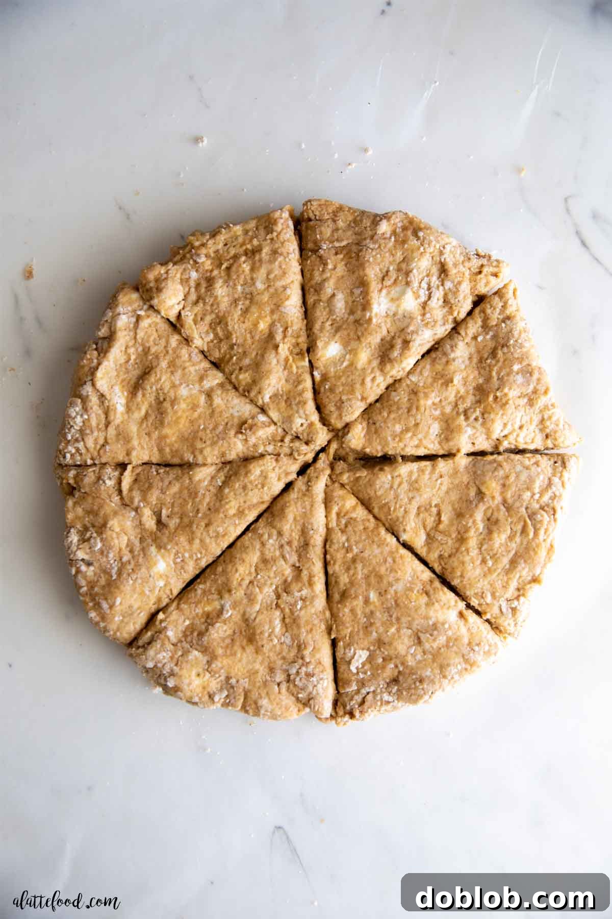 Autumn Spiced Pumpkin Scones with Maple Drizzle 2 Pumpkin scone dough, perfectly formed and ready for baking, resting on a elegant marble cutting board.