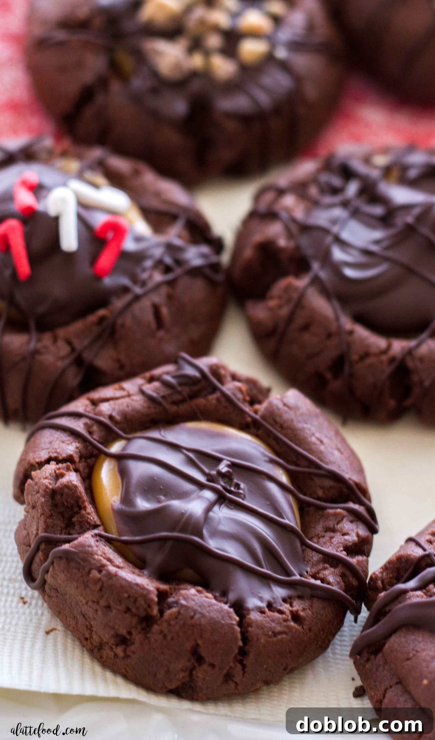 A tray of chocolate thumbprint cookies with golden caramel centers, freshly baked and glistening.