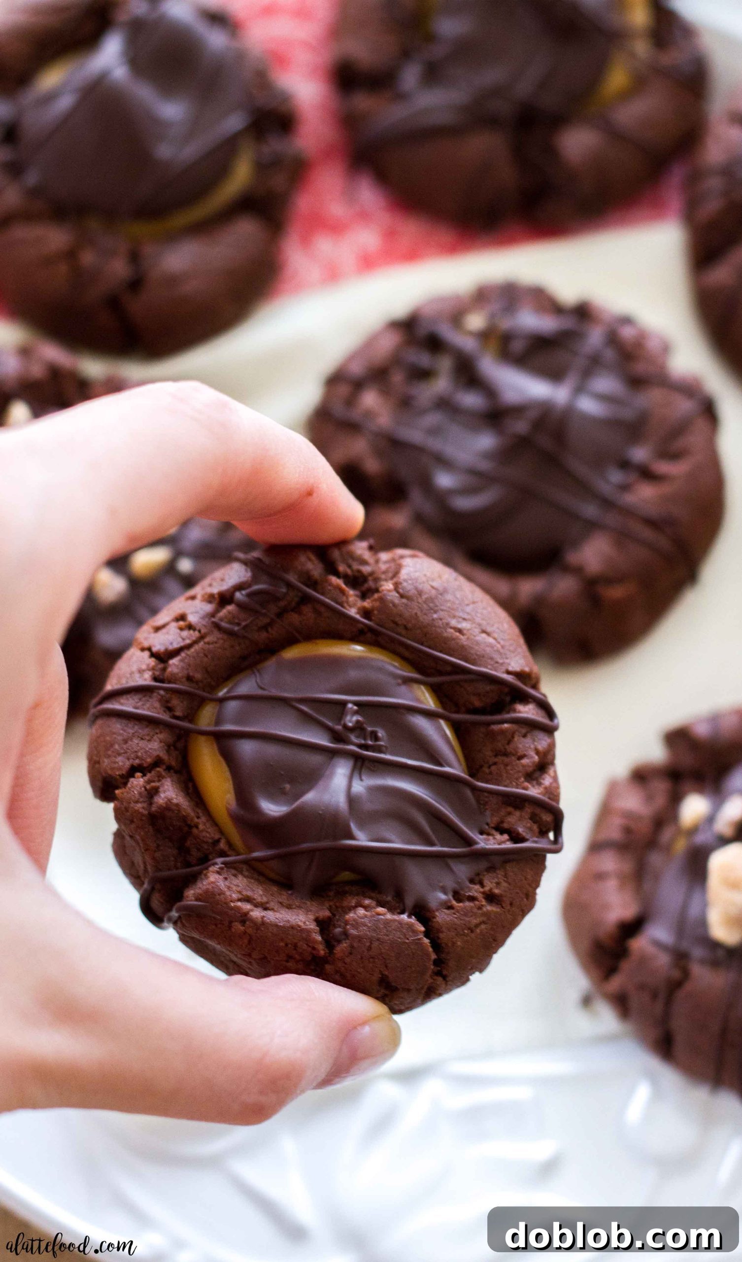 An overhead view of a selection of festive chocolate caramel thumbprint cookies, garnished with sprinkles.