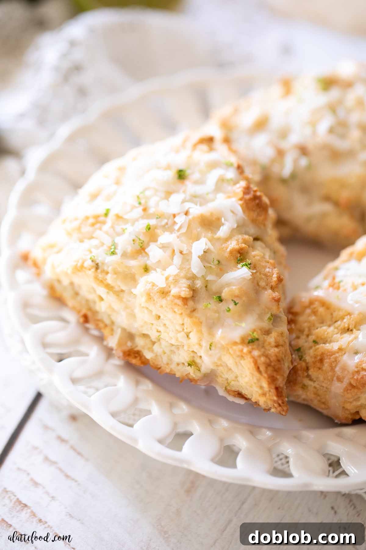 A single, perfectly baked coconut lime scone, generously topped with a bright lime glaze, resting on a white plate, ready to be enjoyed.