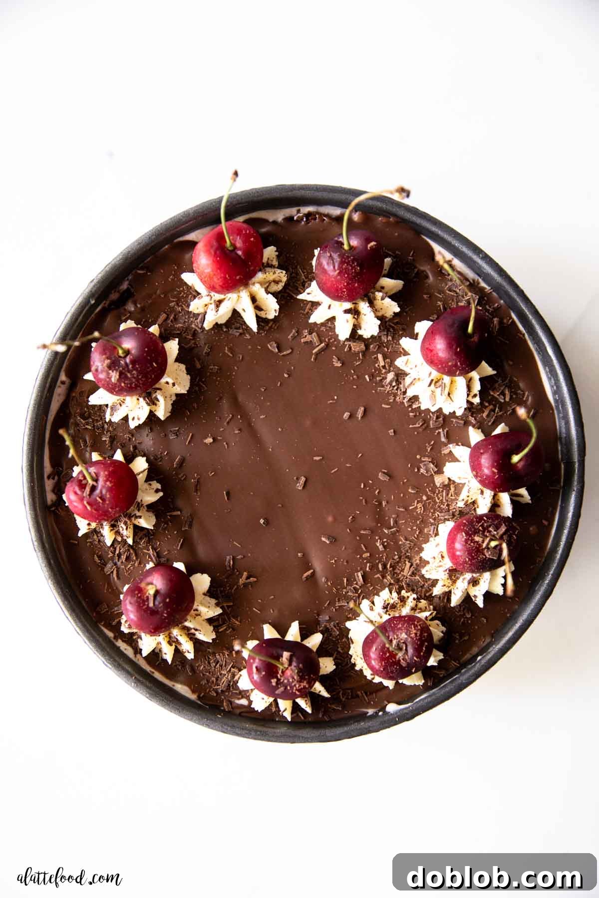 A stunning Black Forest ice cream cake with fudge brownies and cherry ice cream, topped with rich ganache, whipped cream, and fresh cherries.