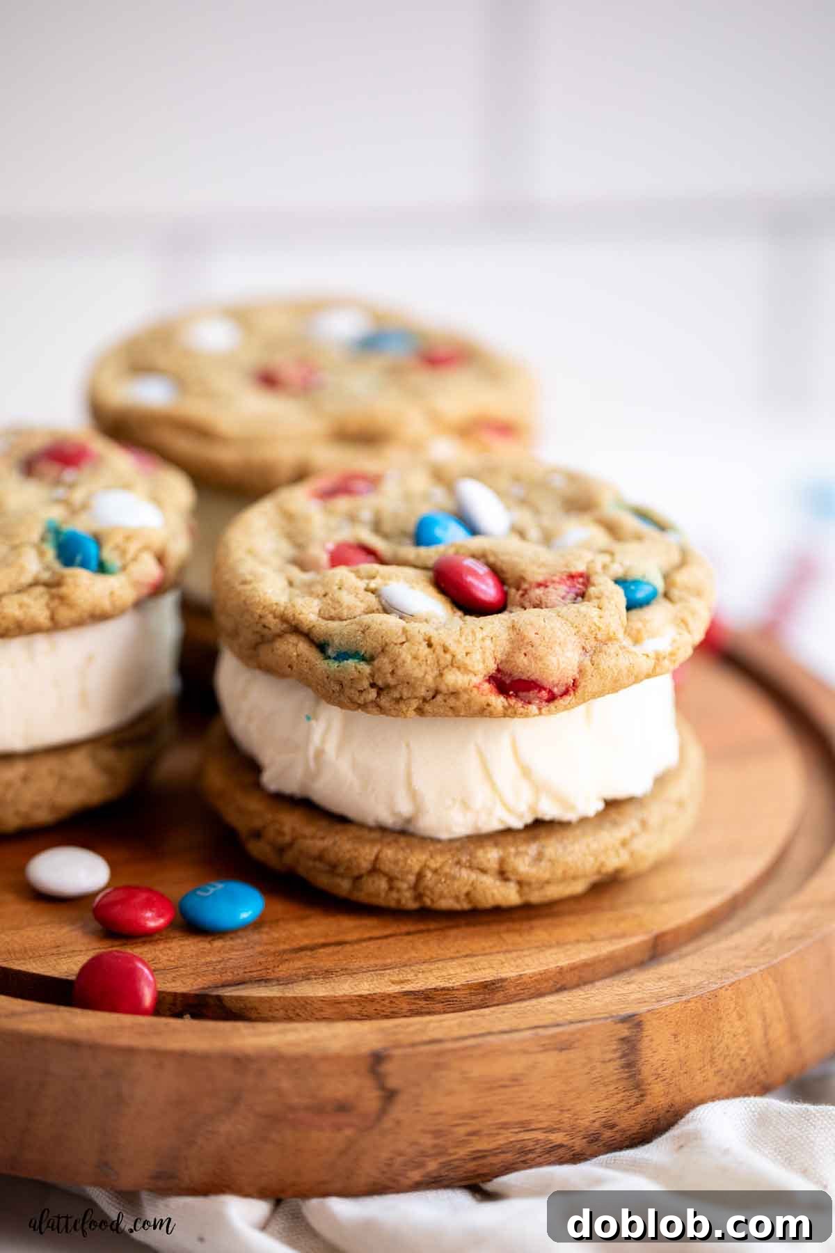 A vibrant M&M cookie ice cream sandwich, revealing its creamy vanilla filling, positioned between two soft M&M cookies. A perfect treat for a hot day.