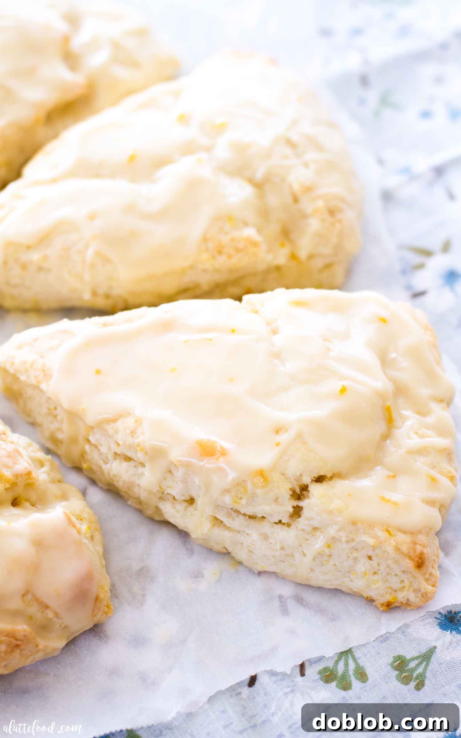 Dreamsicle Orange Cream Scones 4 Beautifully baked orange scones arranged on white parchment paper, highlighting their flaky texture