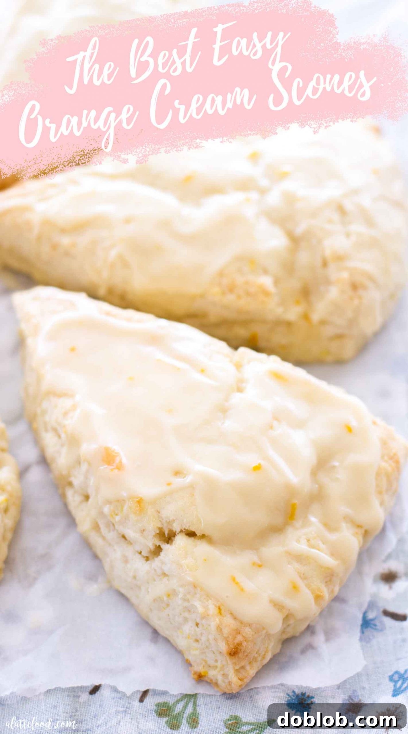 Dreamsicle Orange Cream Scones 8 Single orange cream scone with orange glaze on a blue floral placemat, ready to be eaten