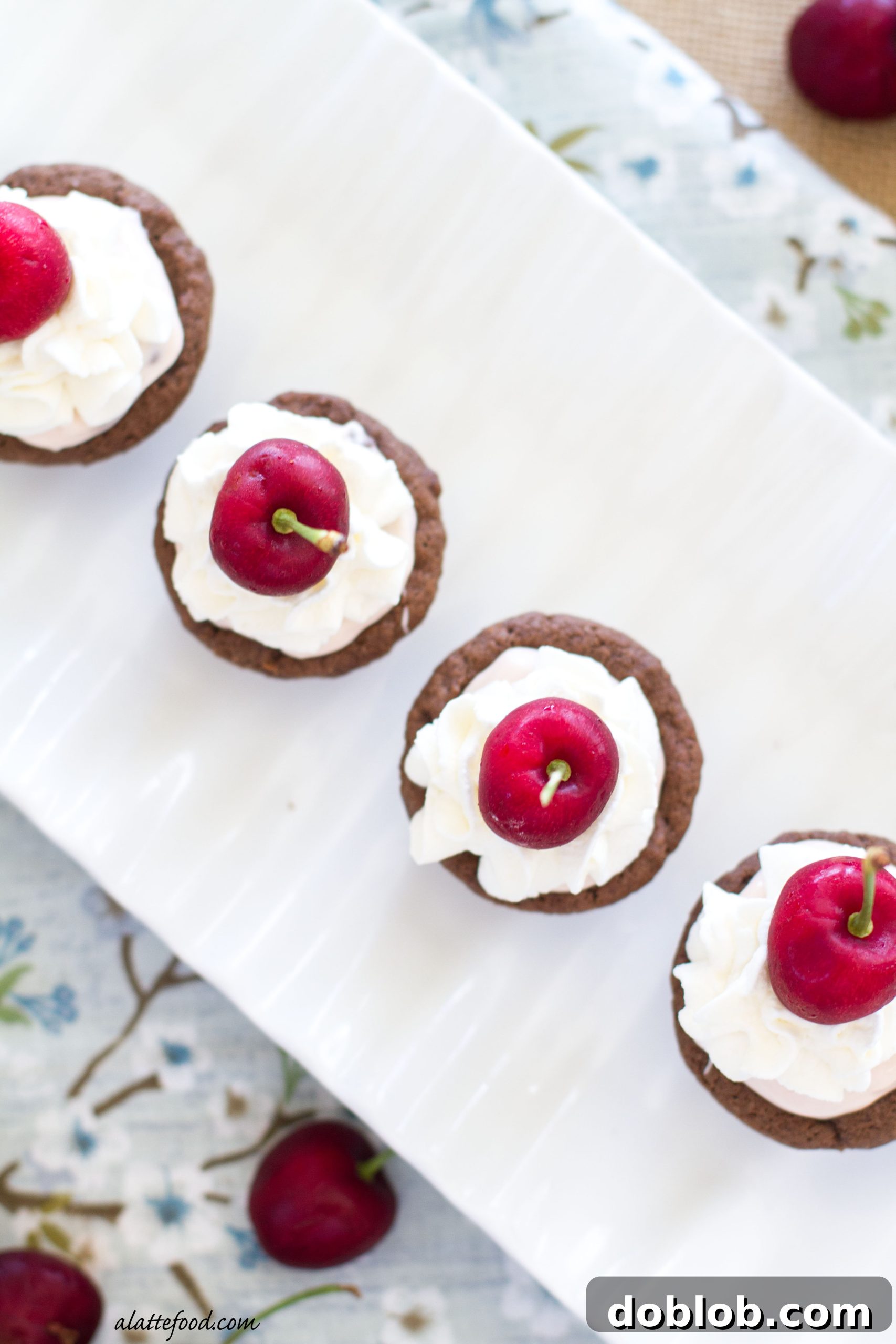 Dr. Pepper Cherry cheesecake cookie cups displayed on a wooden board