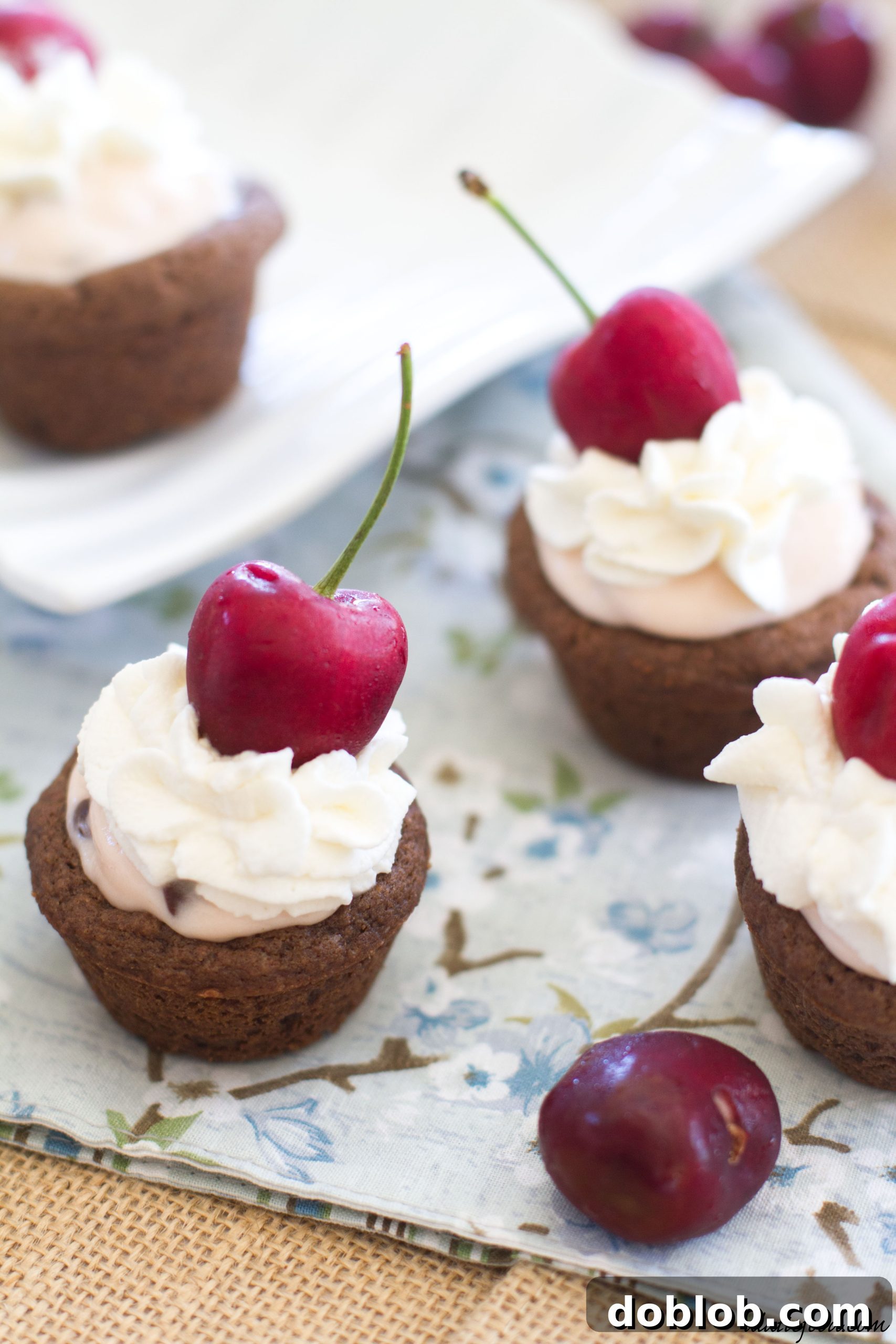 Several Dr. Pepper Cherry cheesecake cookie cups on a wire rack