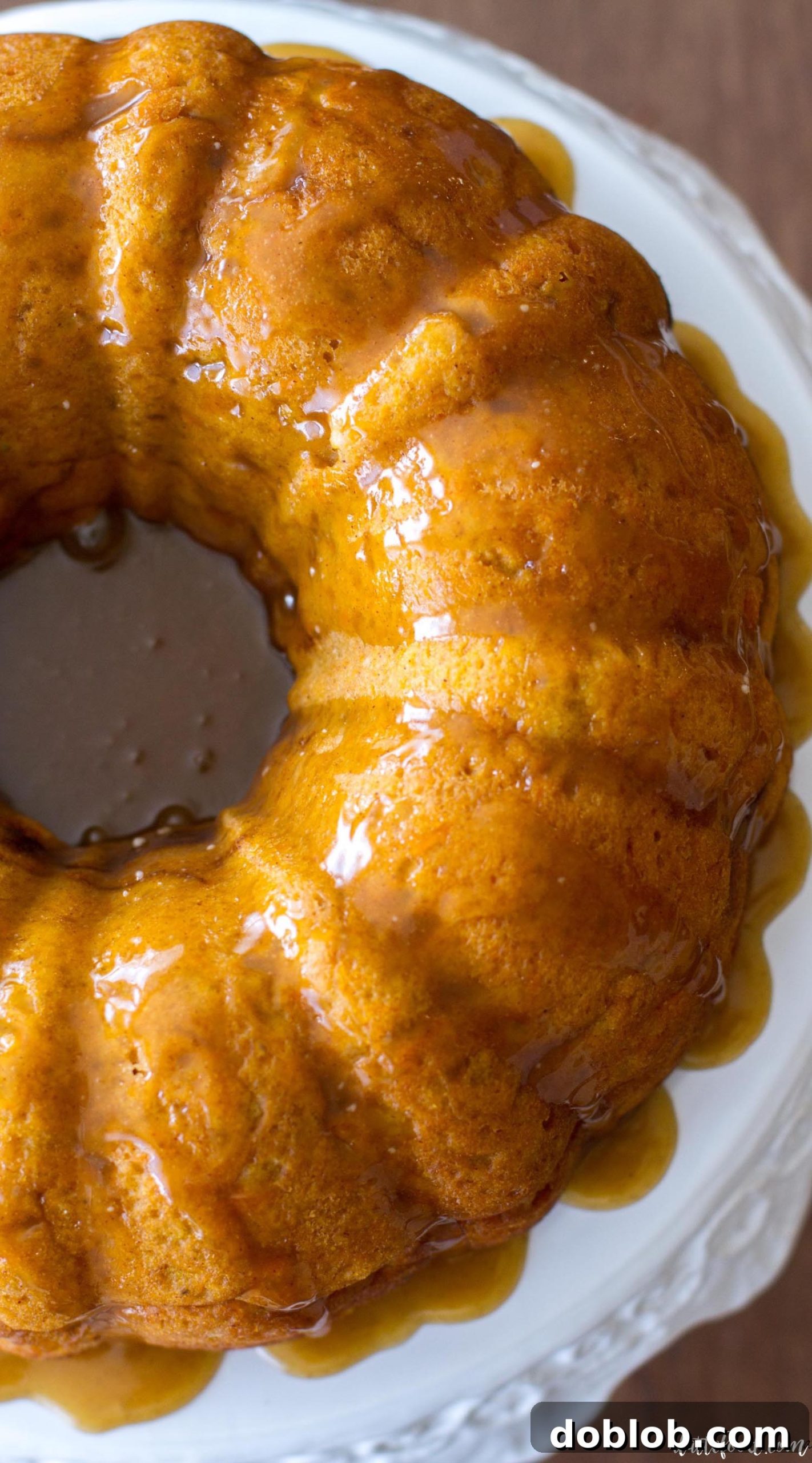 A large, perfectly baked sweet potato bundt cake on a rustic wooden table.