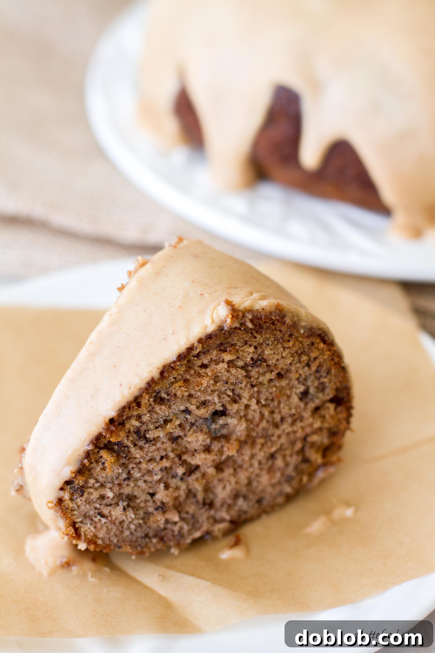 A close-up image of the finished Banana Bundt Cake with Peanut Butter Glaze, showcasing its golden-brown crust and smooth, inviting topping.