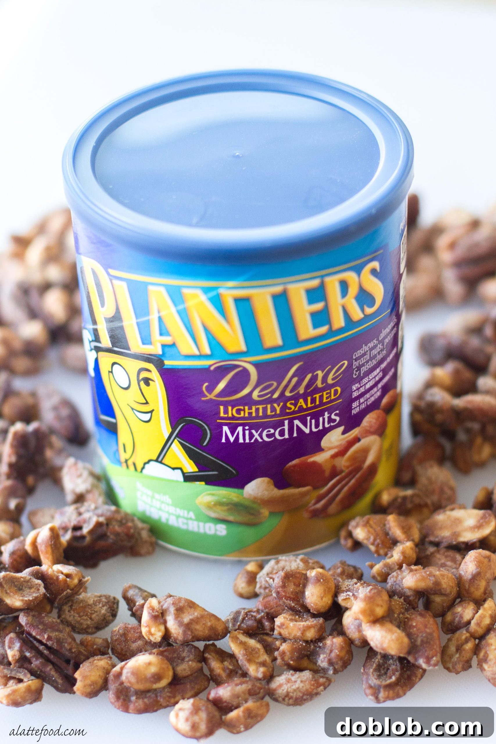 Pile of glistening apple spice candied nuts cooling on parchment paper