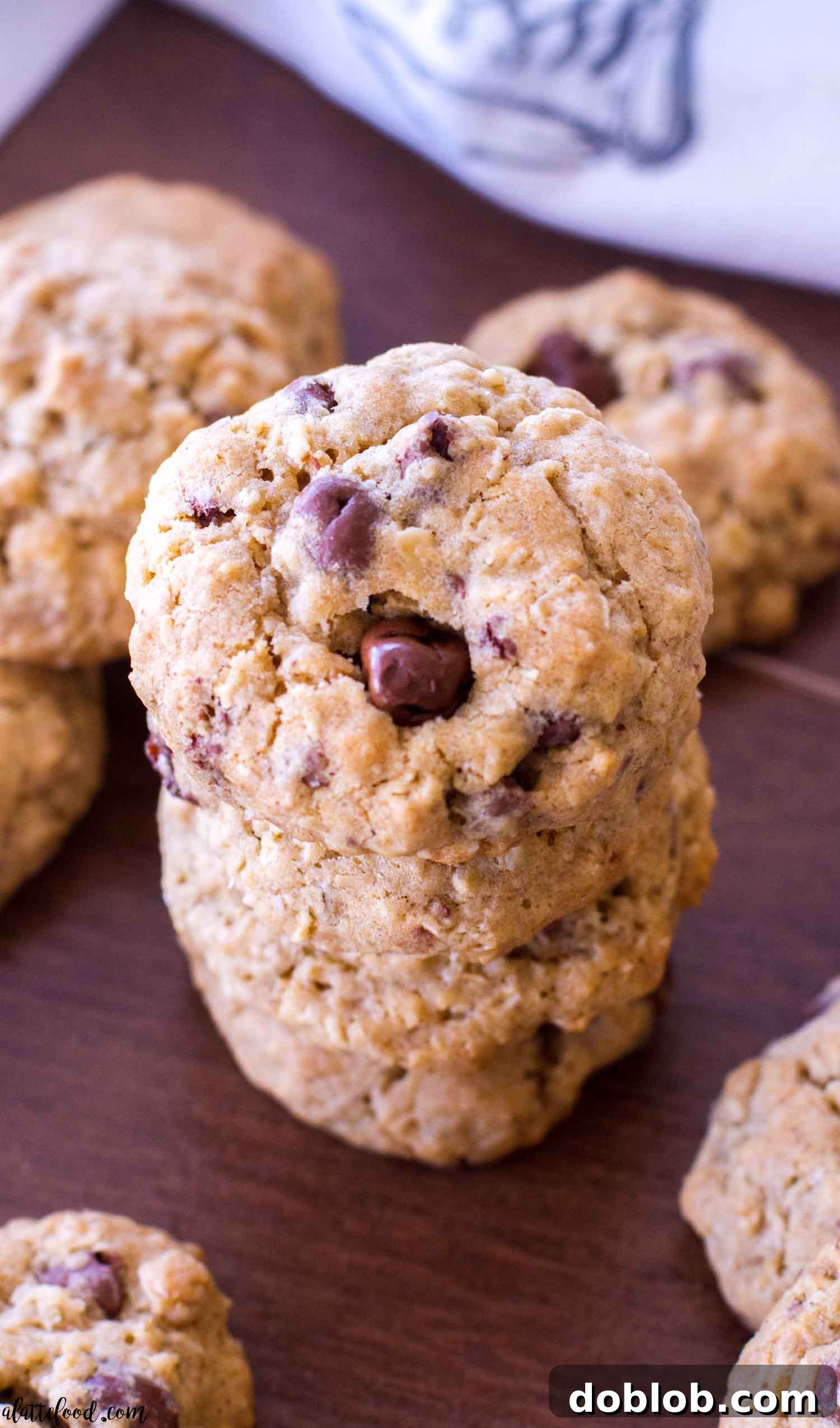An overhead shot showcasing a delightful stack of oatmeal chocolate covered raisin cookies, with a tempting glimpse of their deliciousness.