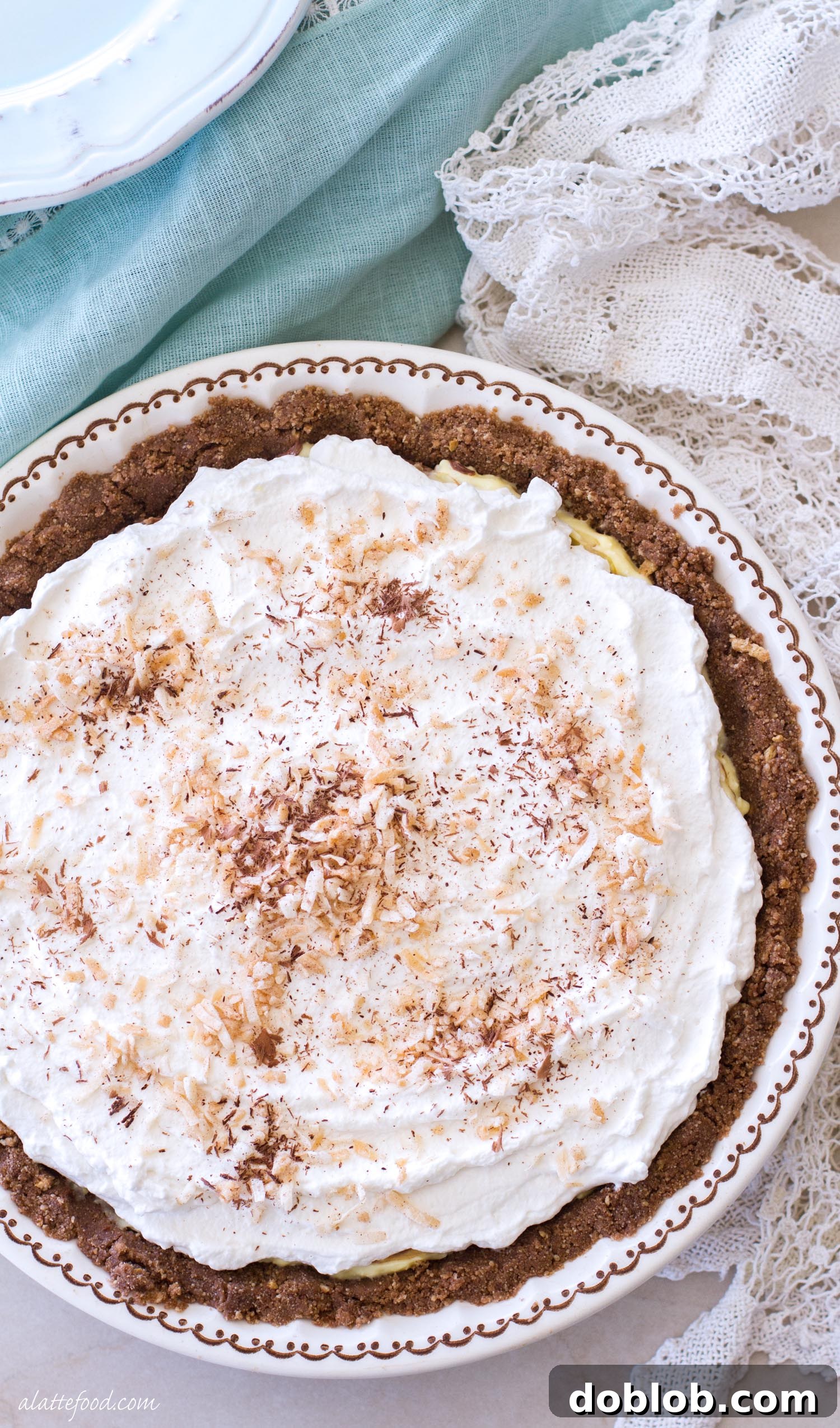 Overhead shot of a no-bake chocolate coconut cream pie in a pie plate, garnished with toasted coconut and chocolate shavings.